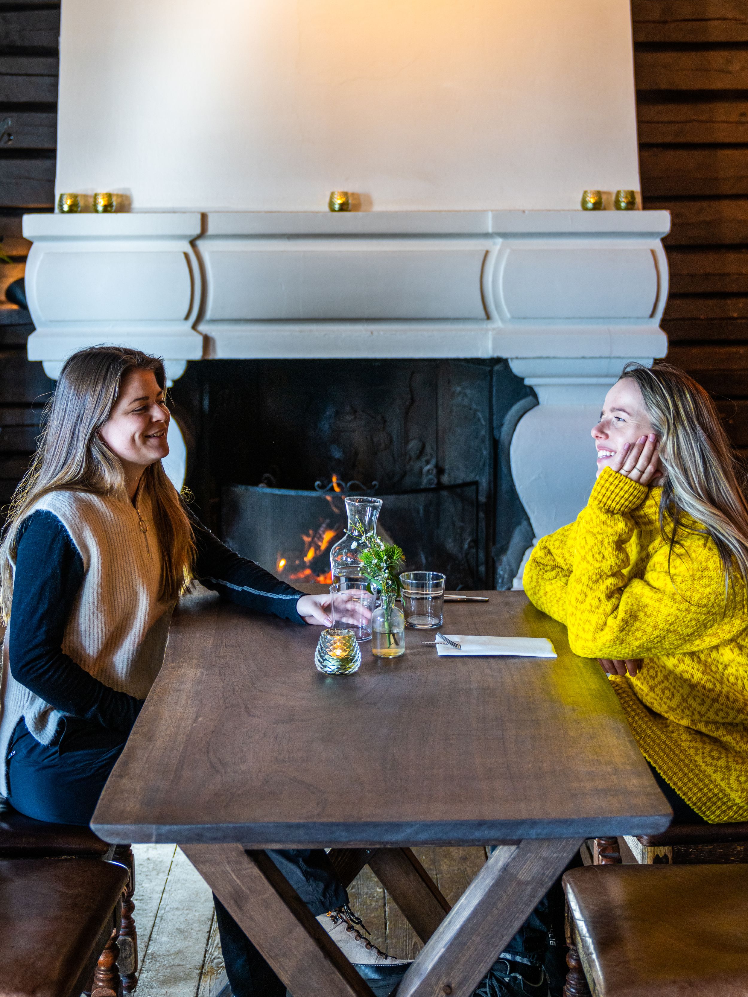 Two friends sitting by the fireplace at Grefsenkollen restaurant