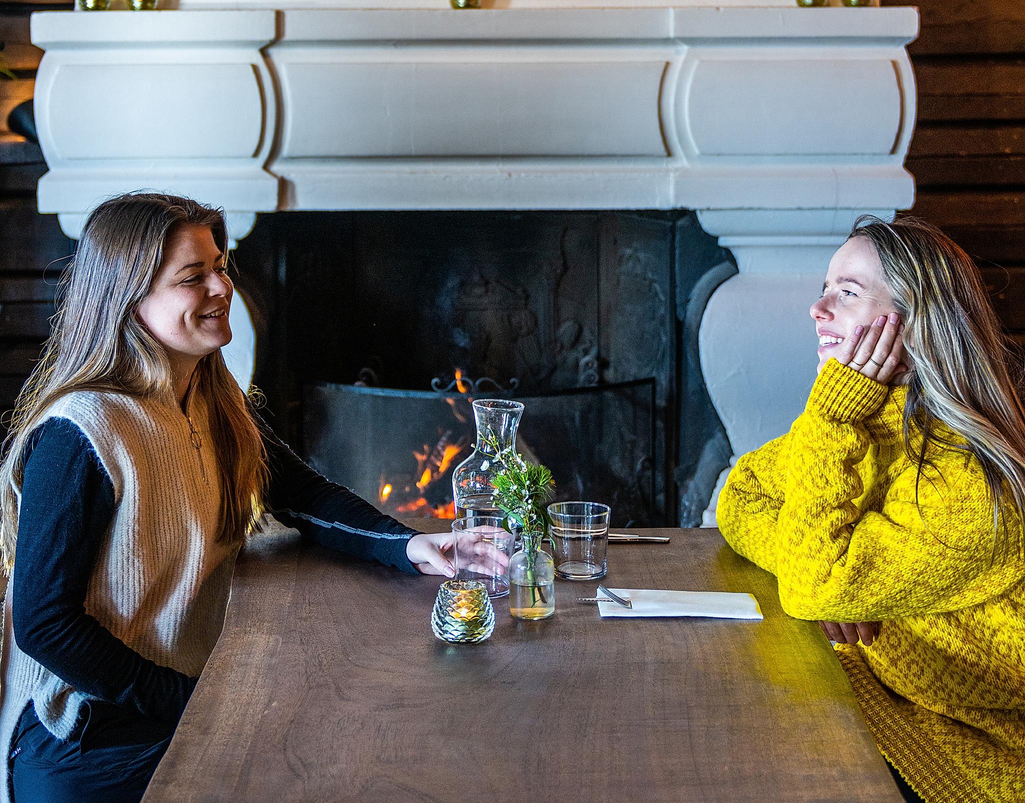 Two friends sitting by the fireplace at Grefsenkollen restaurant