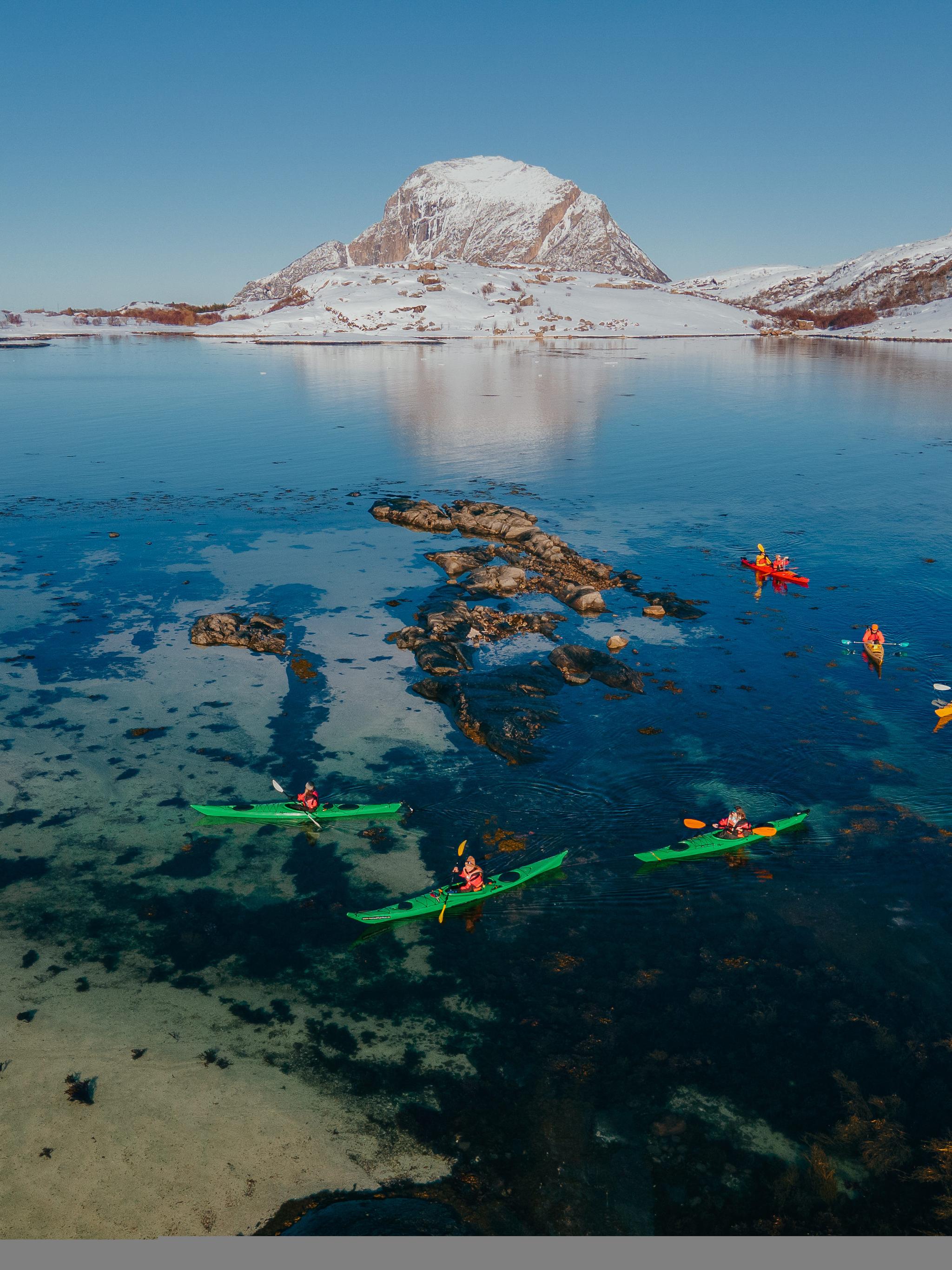 People kayaking in winter landscape.