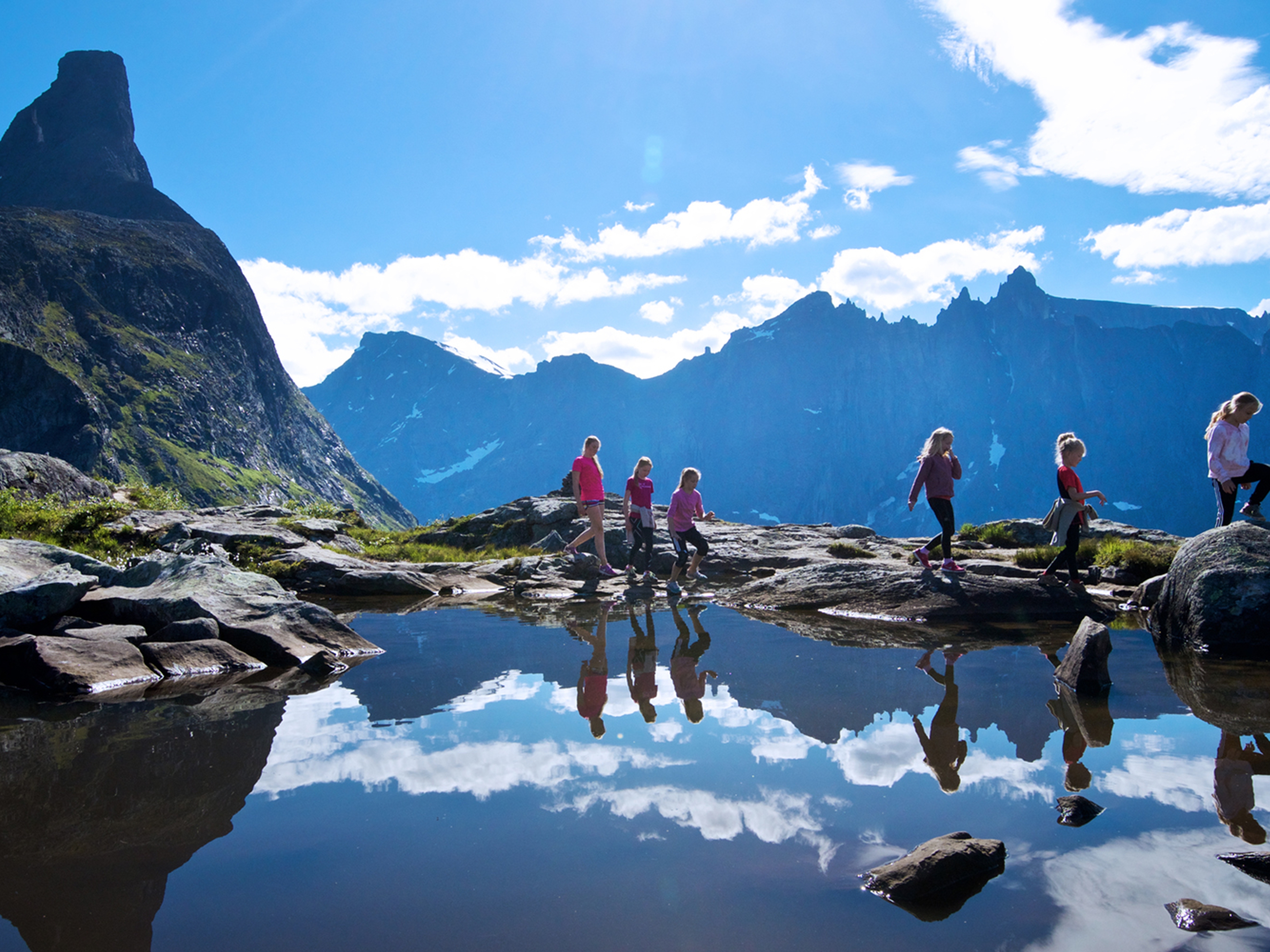 A group of people hiking in sunny weather in Romsdal