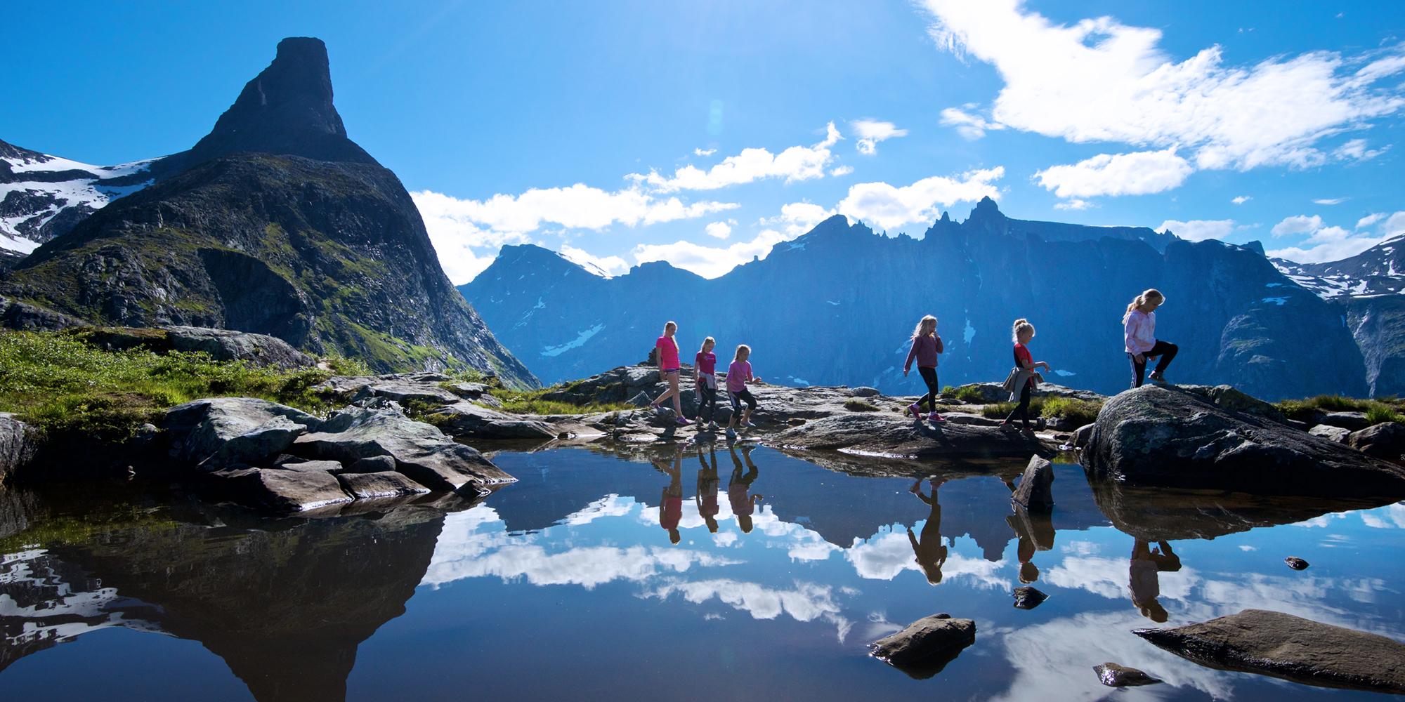 A group of people hiking in sunny weather in Romsdal
