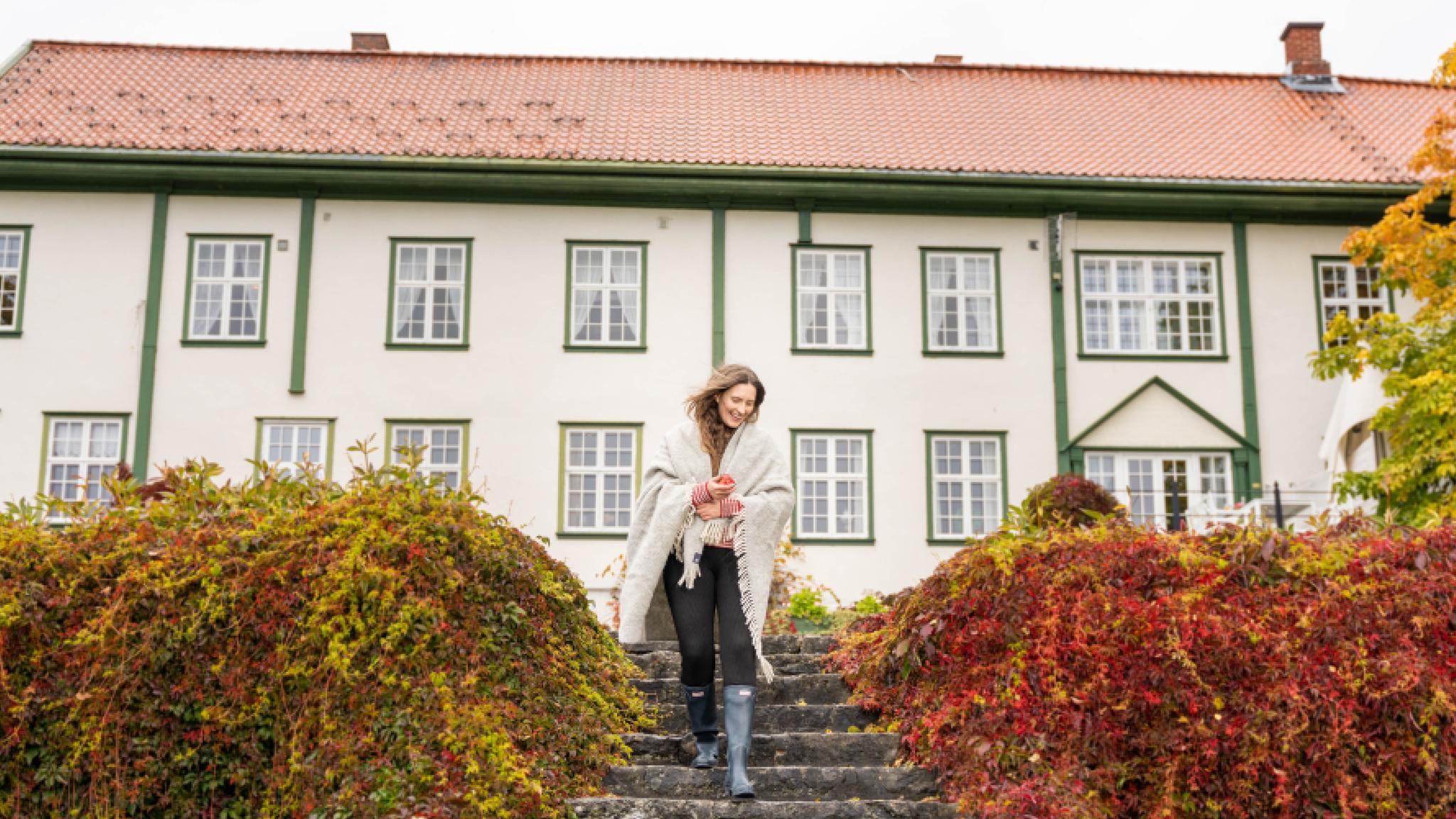 A woman goes for a stroll in the garden at Hoel Farm, Eastern Norway.