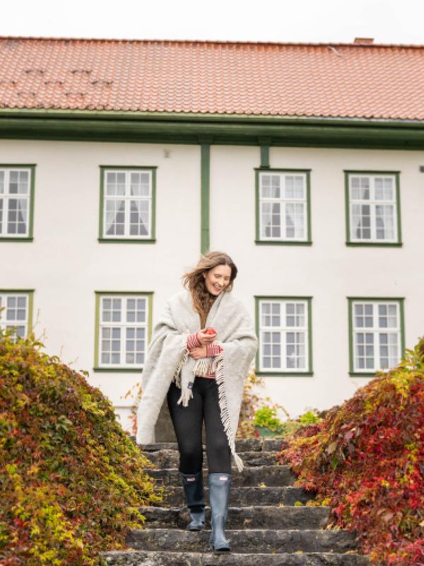 A woman goes for a stroll in the garden at Hoel Farm, Eastern Norway.