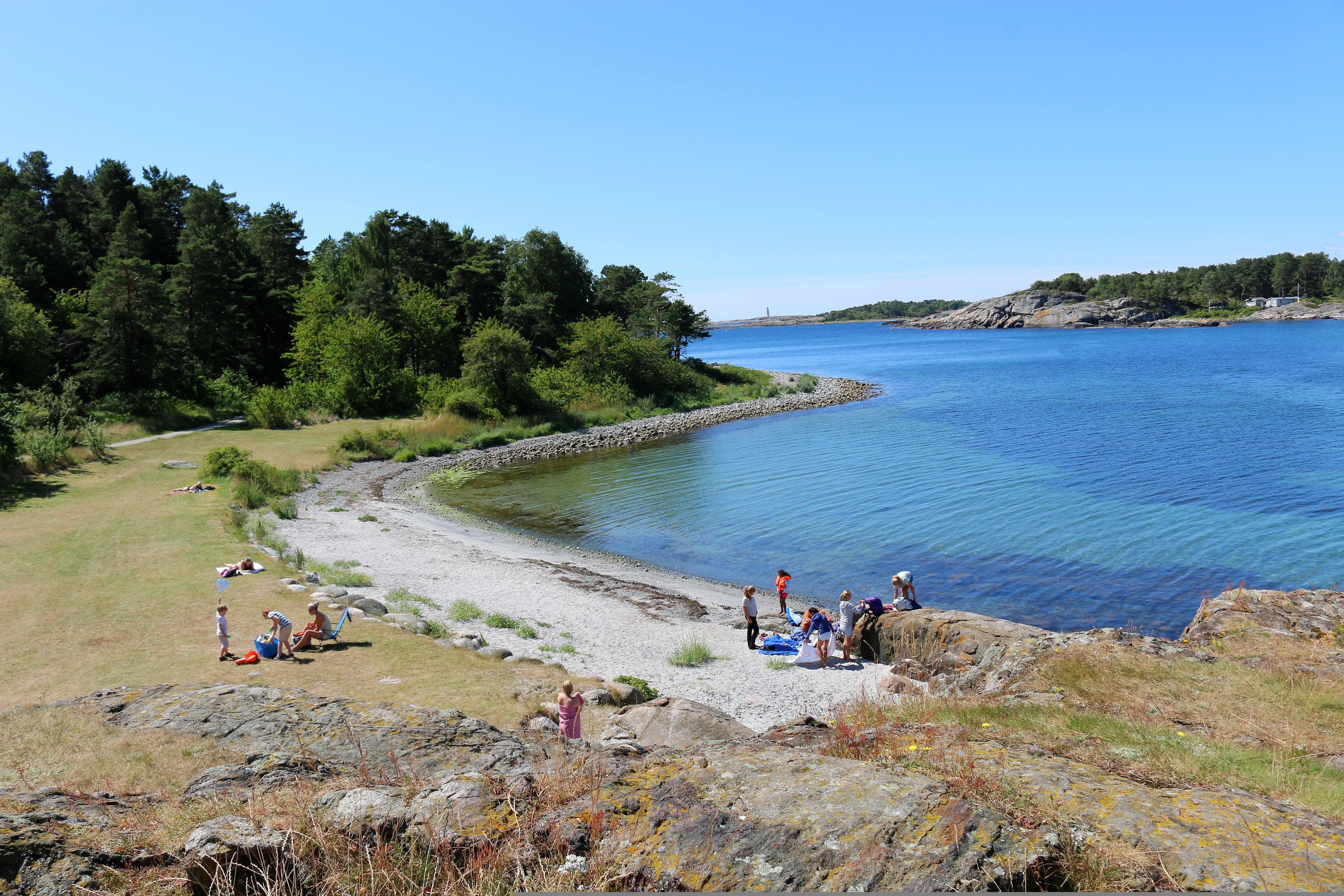 Groups of people by the water in Raet national park in Arendal, Southern Norway.
