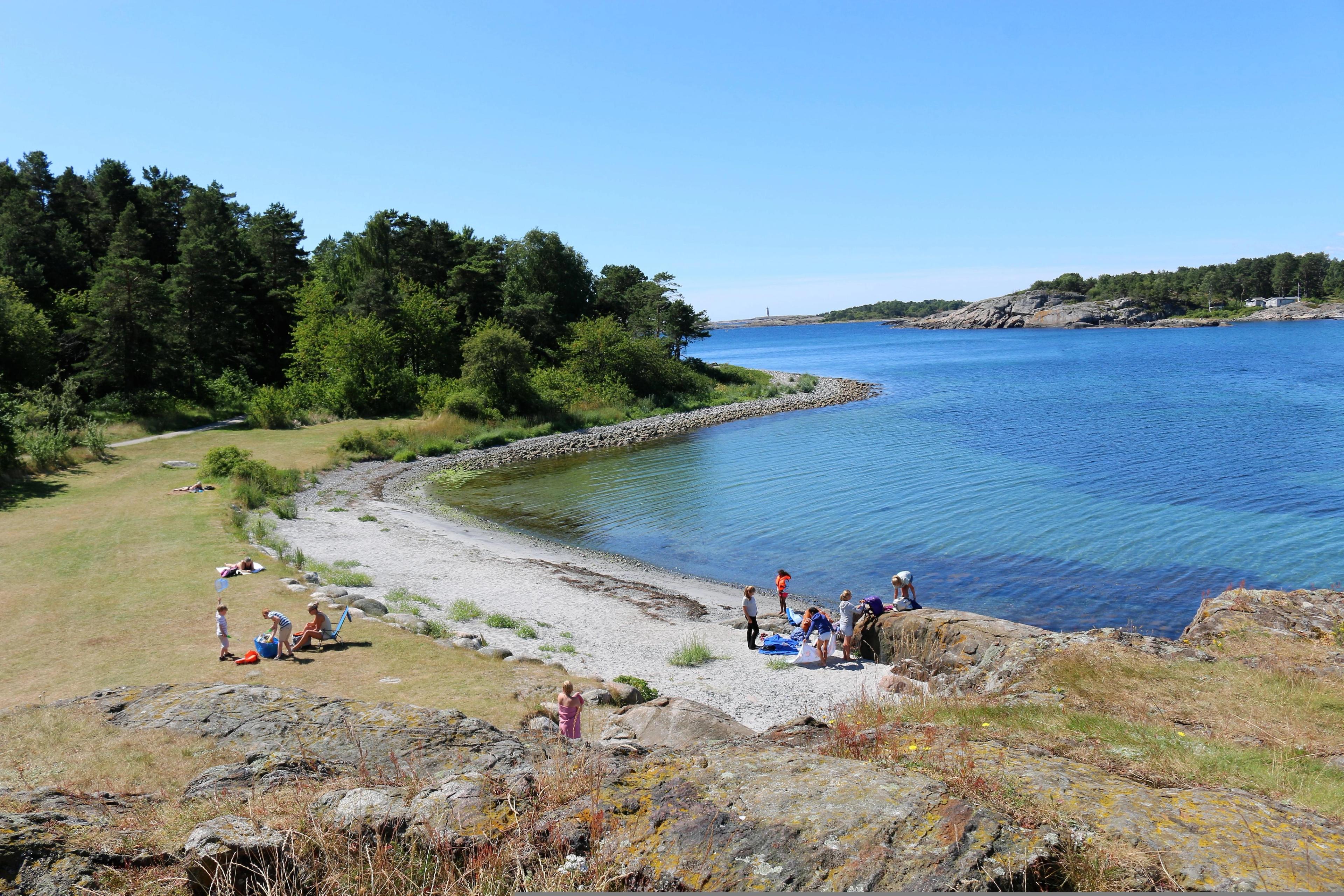 Groups of people by the water in Raet national park in Arendal, Southern Norway.