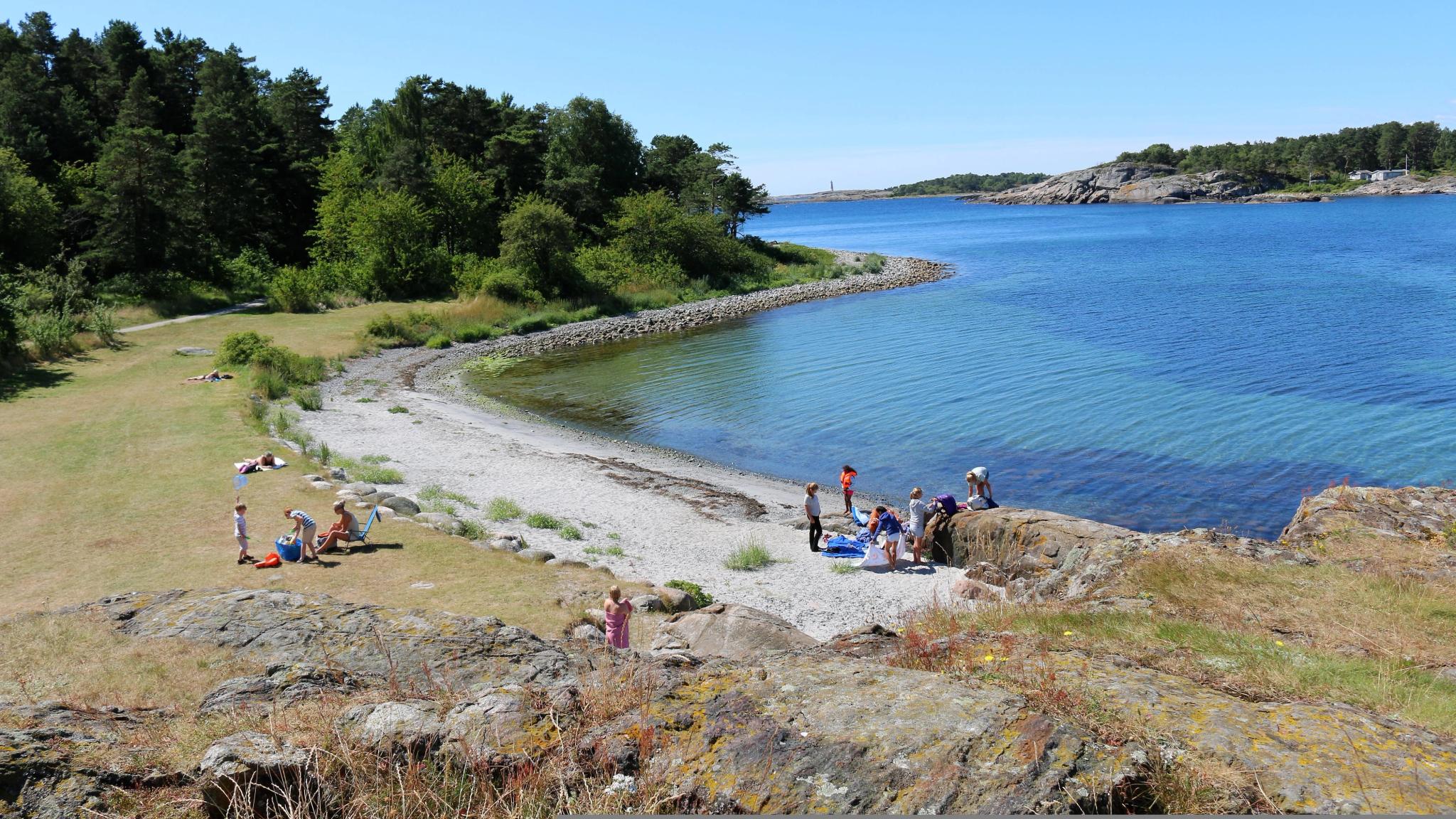 Groups of people by the water in Raet national park in Arendal, Southern Norway.