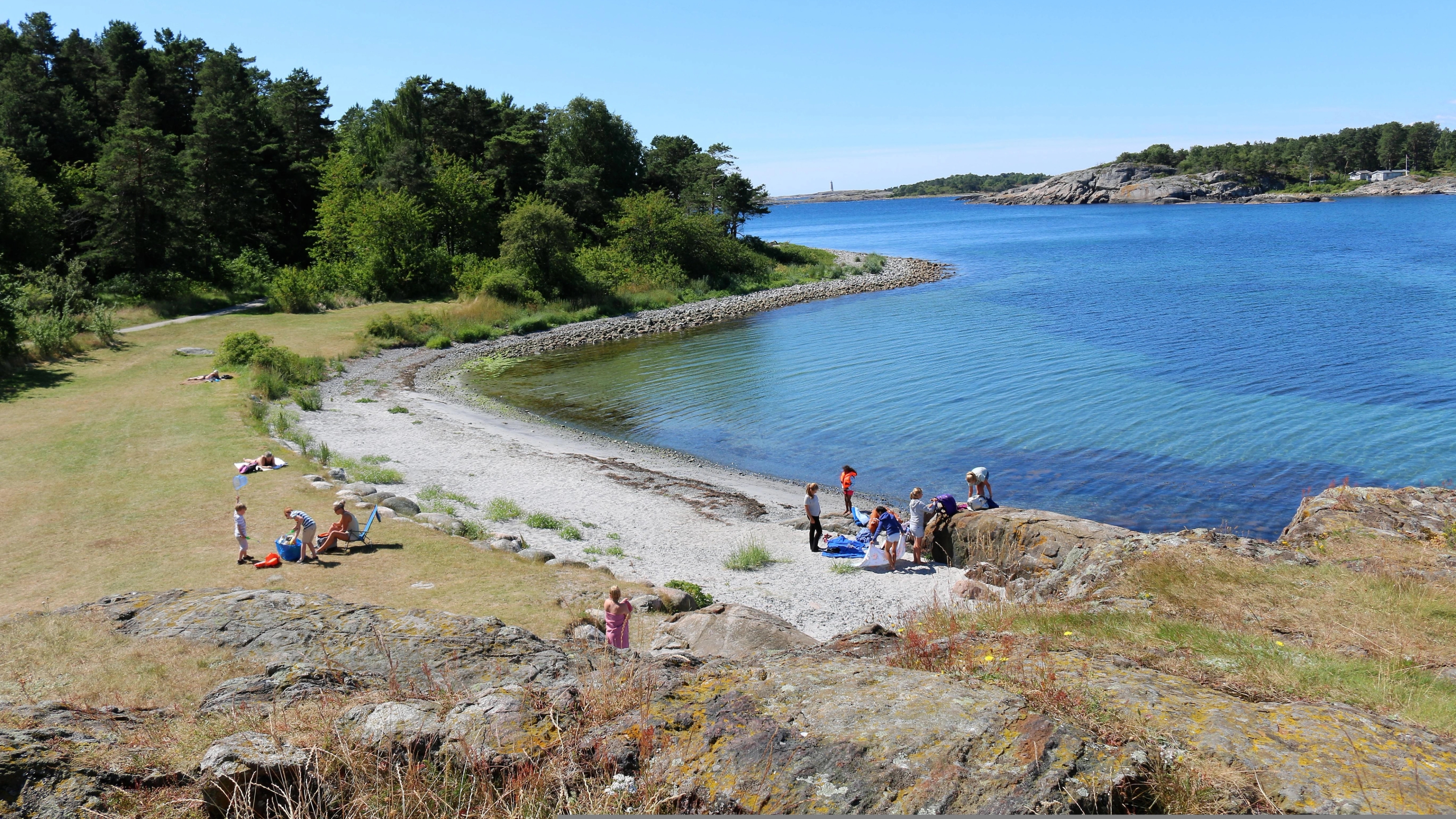 Groups of people by the water in Raet national park in Arendal, Southern Norway.