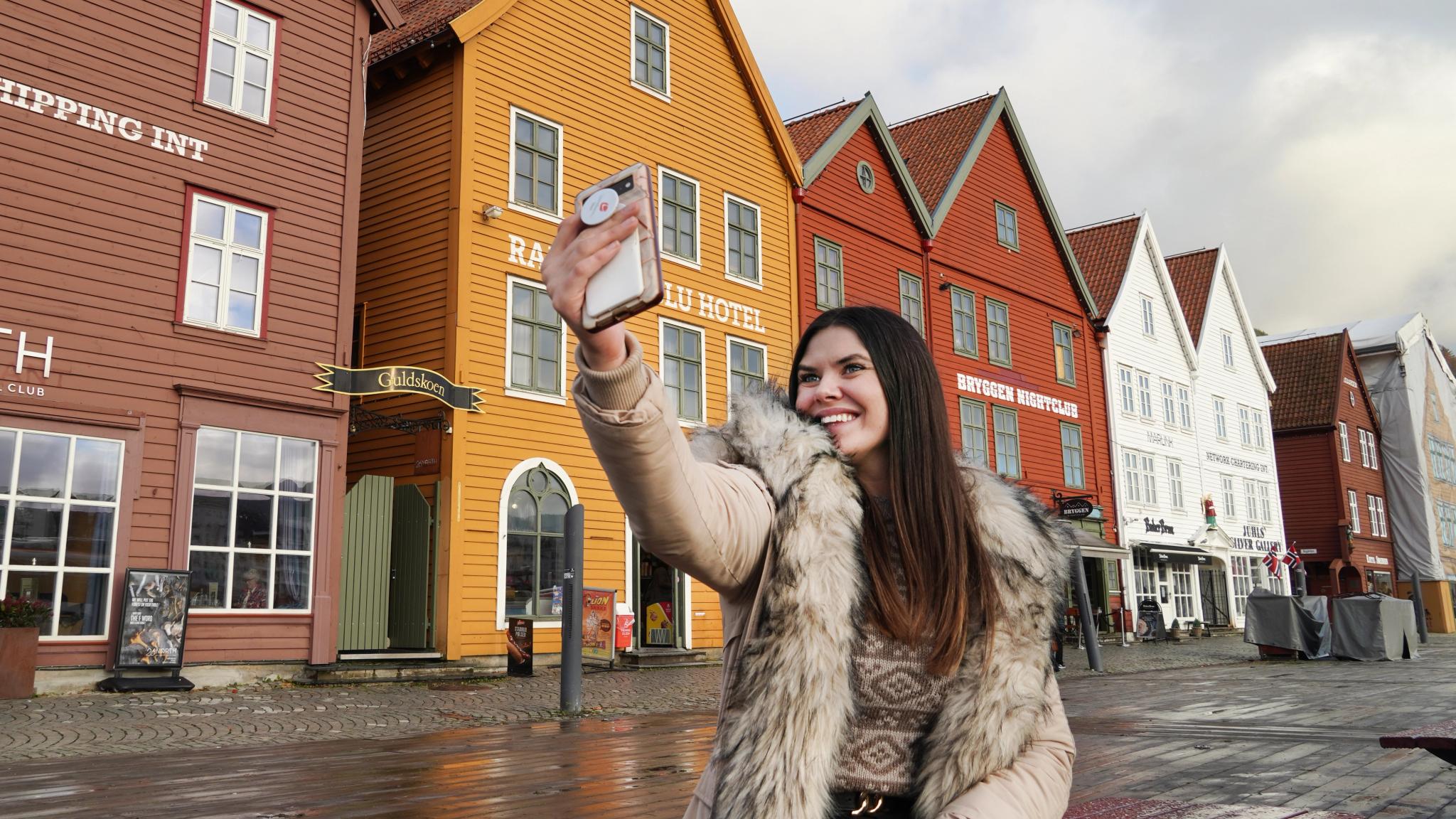 Girl taking a selfie at Bryggen in Bergen