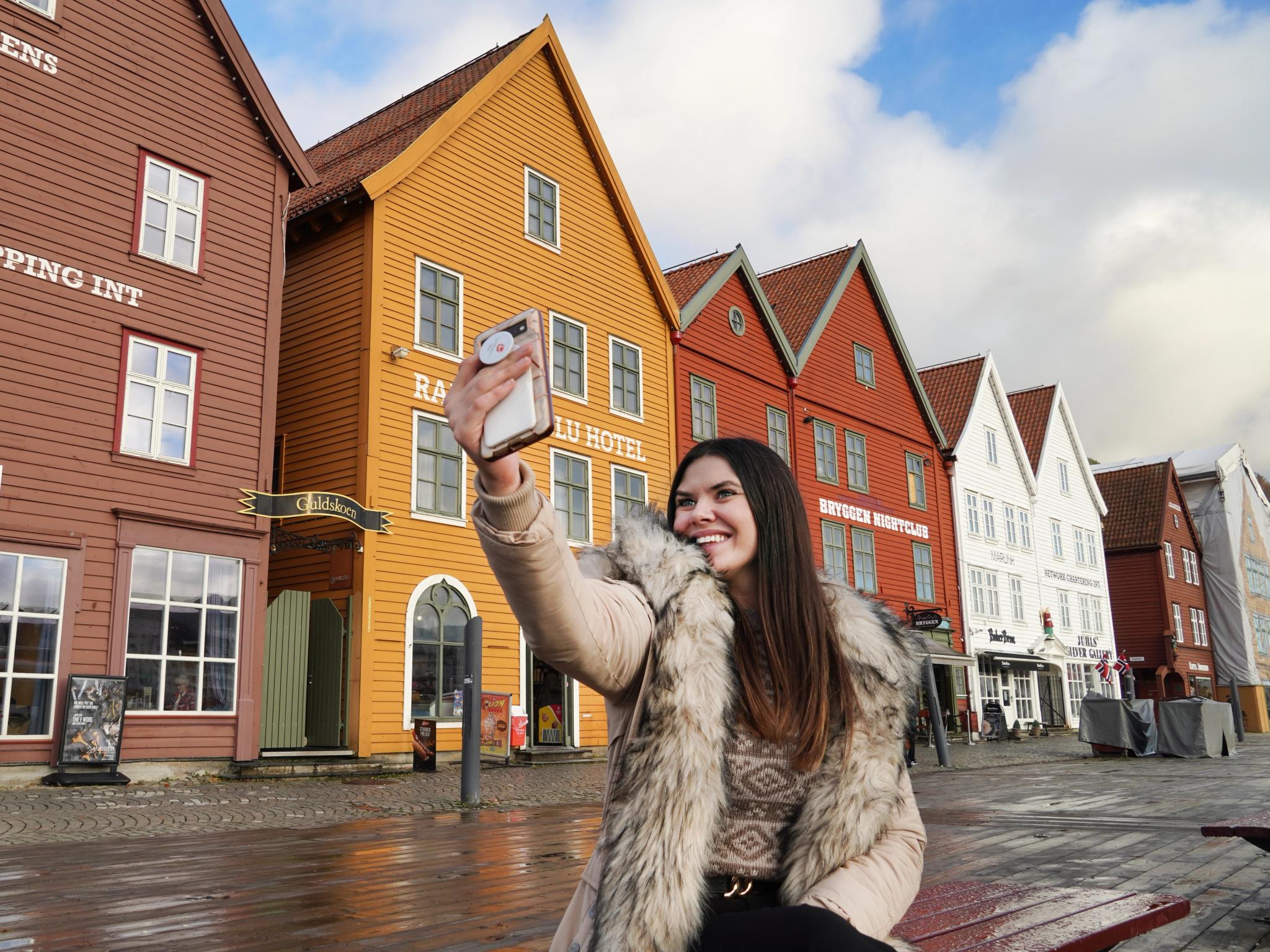 Girl taking a selfie at Bryggen in Bergen