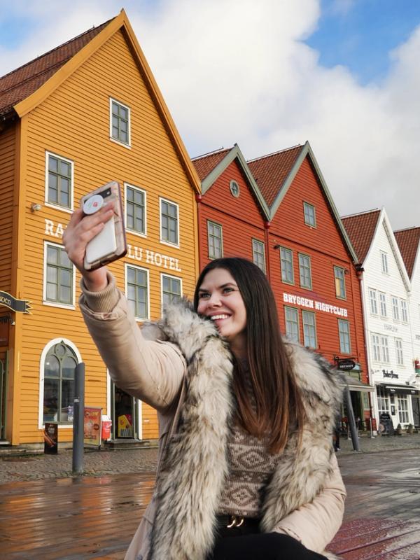 Girl taking a selfie at Bryggen in Bergen