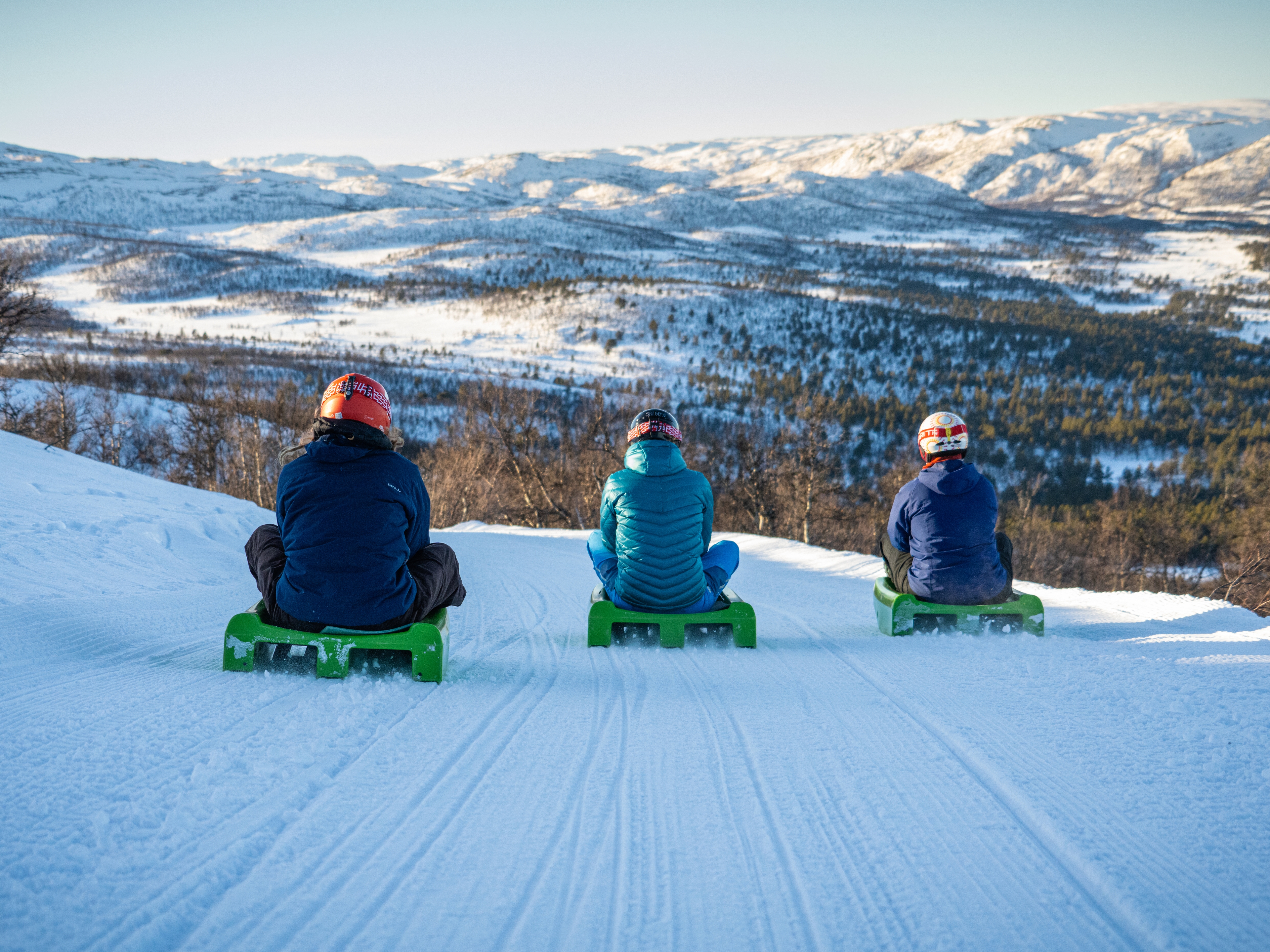 Friends going tobogganing at Dagali Fjellpark, Eastern Norway.