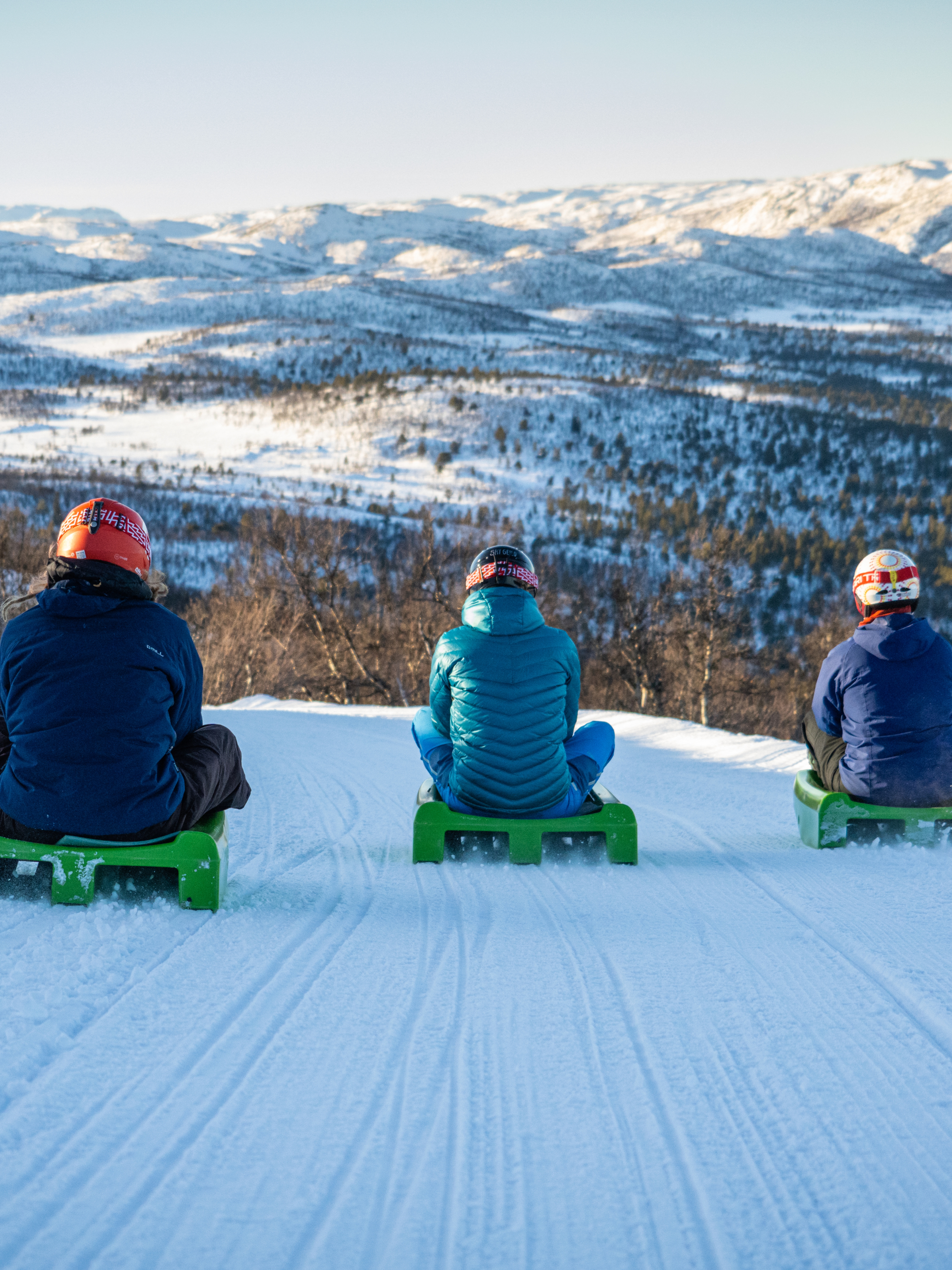 Friends going tobogganing at Dagali Fjellpark, Eastern Norway.