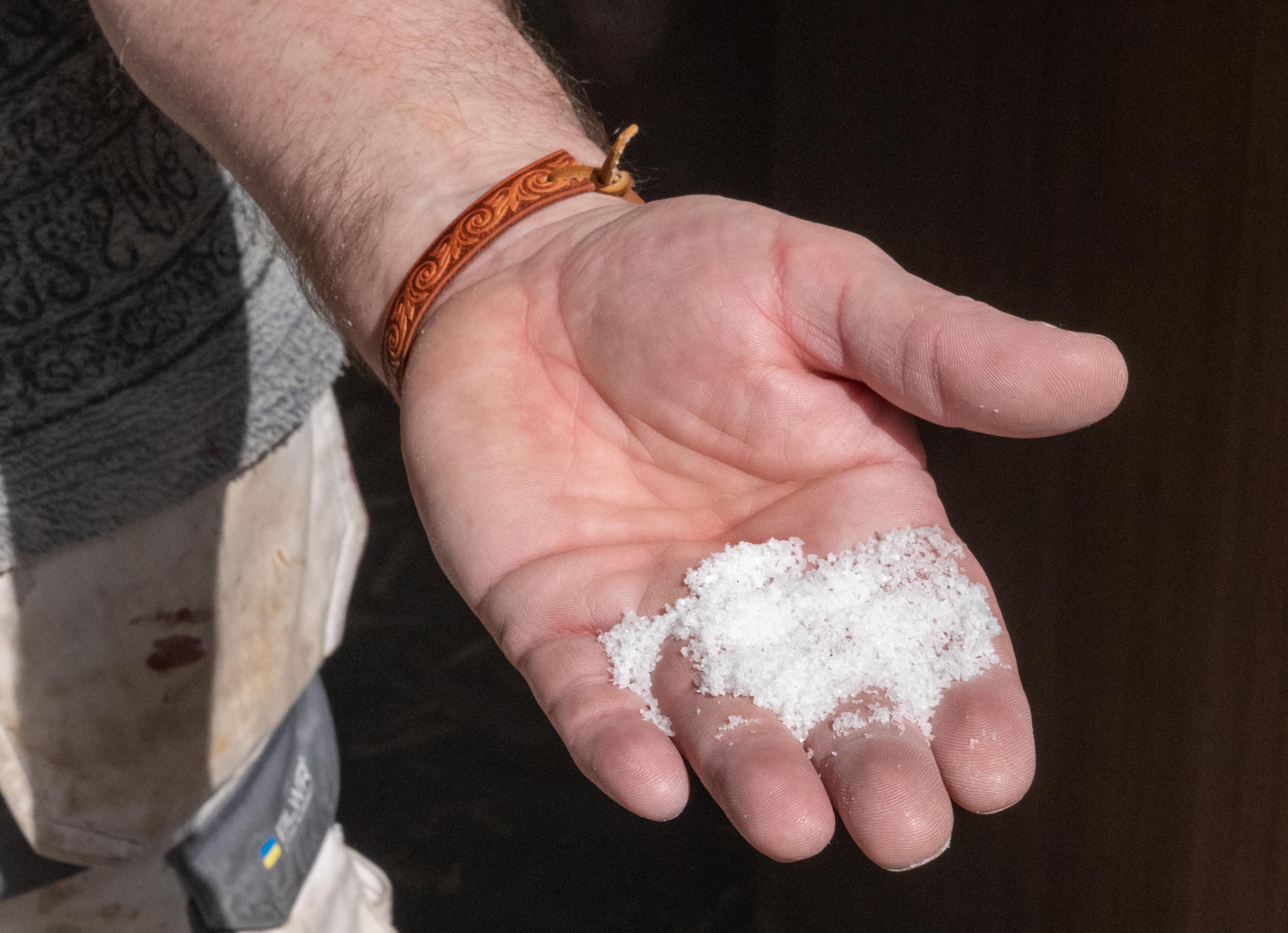 A hand holding salt produced from the salt sea water from Saltstraumen, outside of Bodø, Northern Norway.