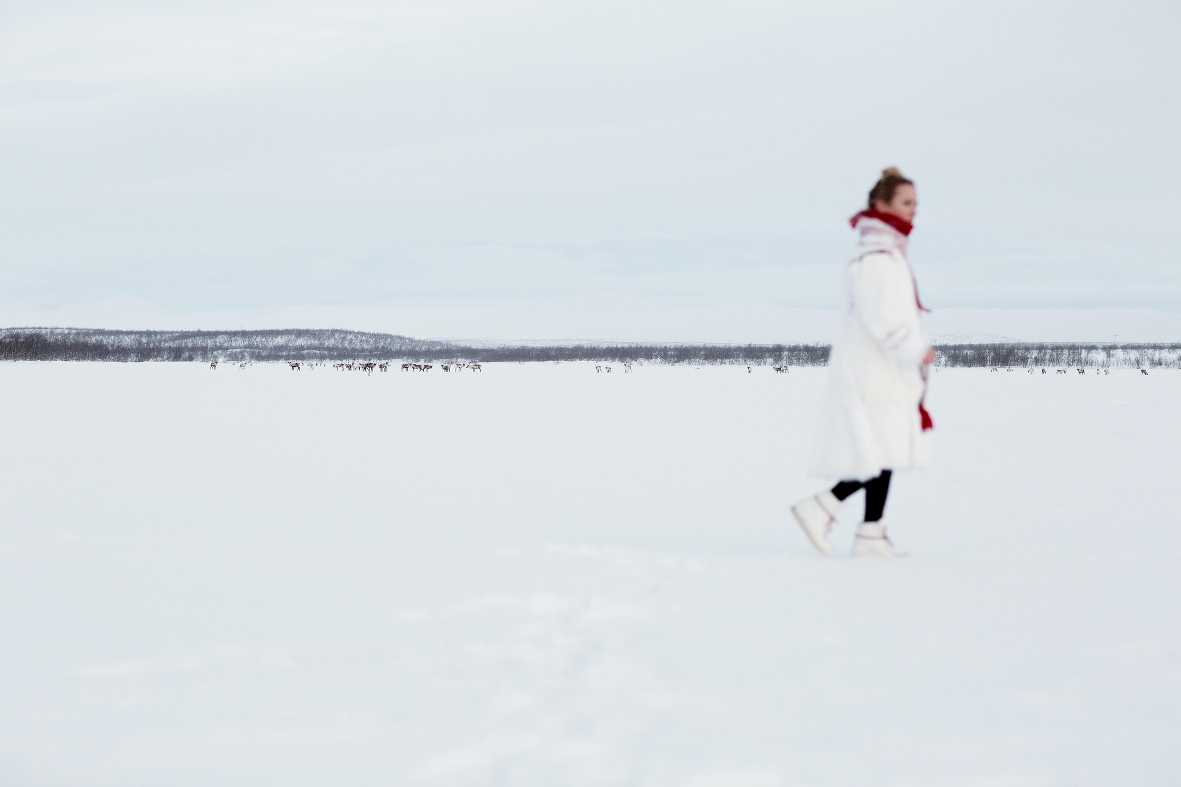 Elle Márjá Eira out of focus, walking in the snow in Northern Norway