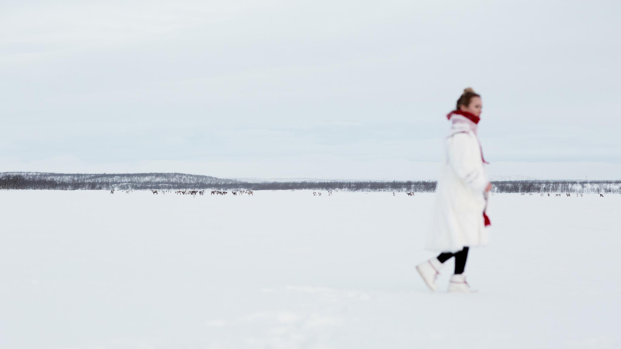 Elle Márjá Eira out of focus, walking in the snow in Northern Norway