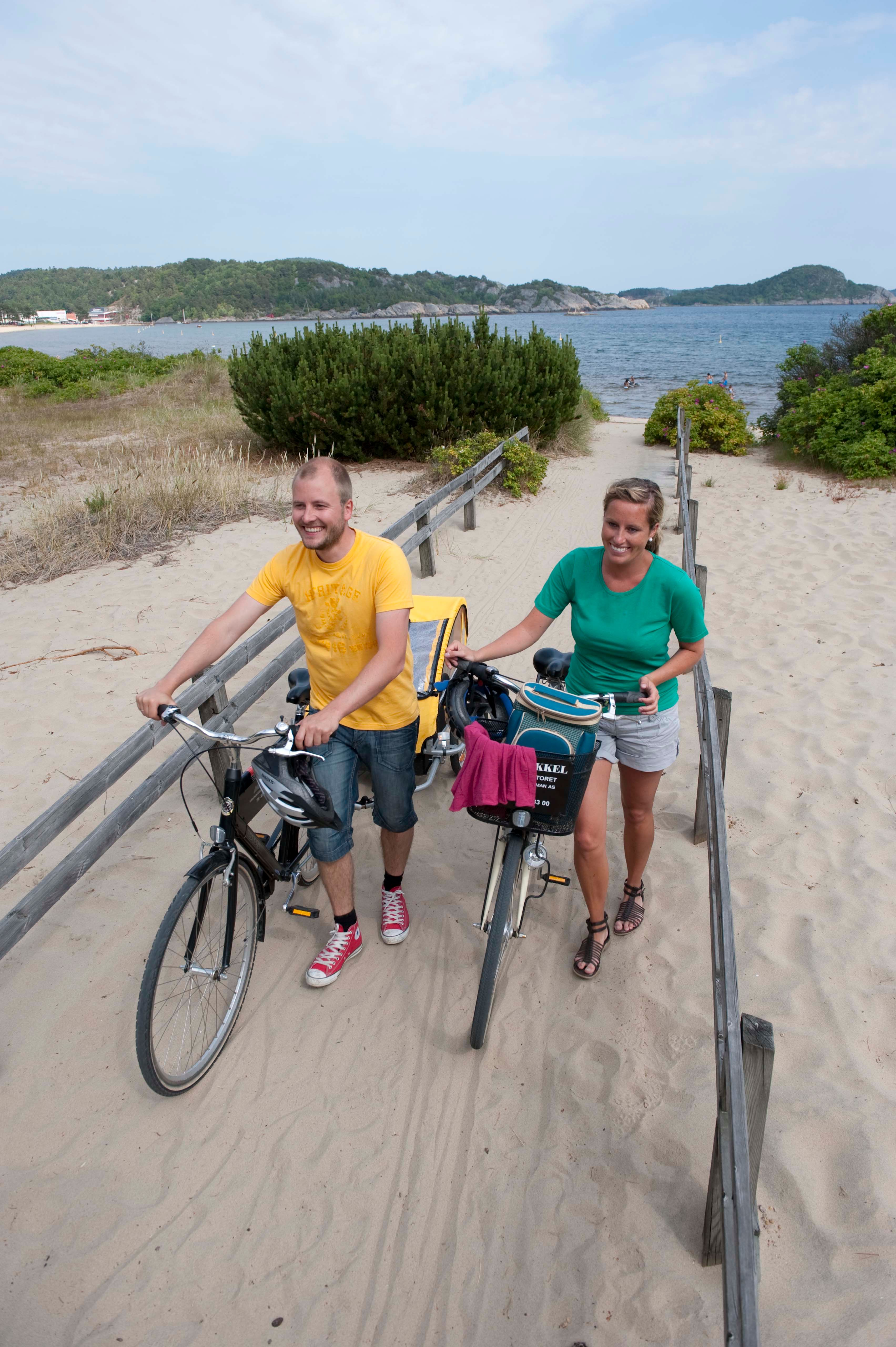 A couple with bikes on the Sjøsanden beach in Mandal, Southern Norway