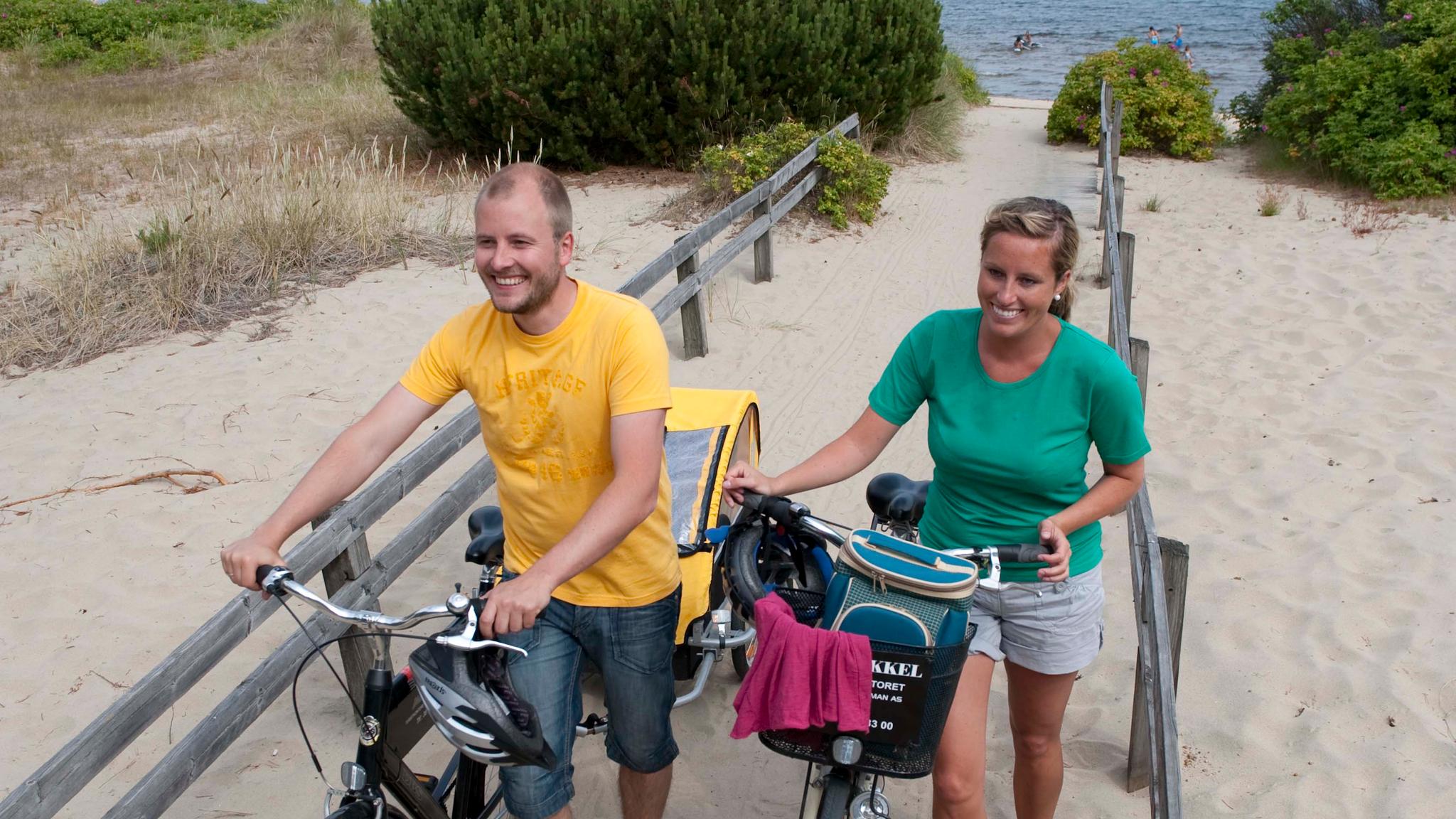 A couple with bikes on the Sjøsanden beach in Mandal, Southern Norway