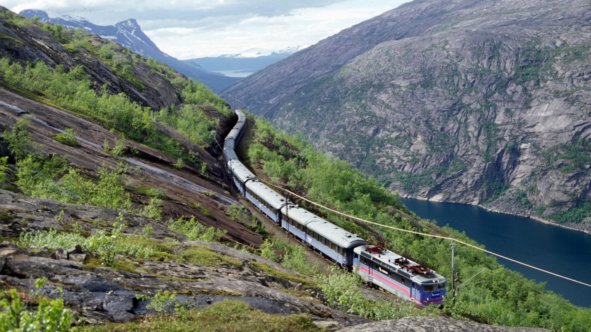 A train on the Ofotbanen in a beautiful river and mountain landscape, Northern Norway