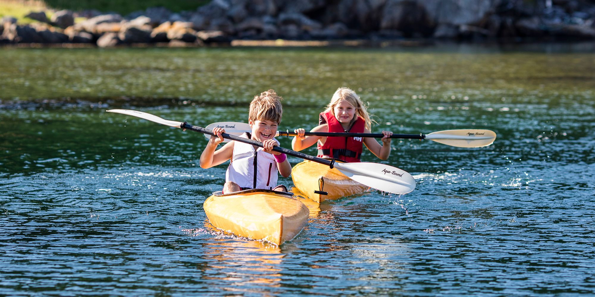 Two children are kayaking in the waters by the island Hidra outside Flekkefjord in Southern Norway