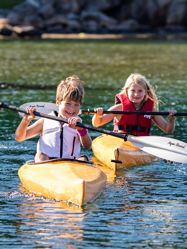 Two children are kayaking in the waters by the island Hidra outside Flekkefjord in Southern Norway