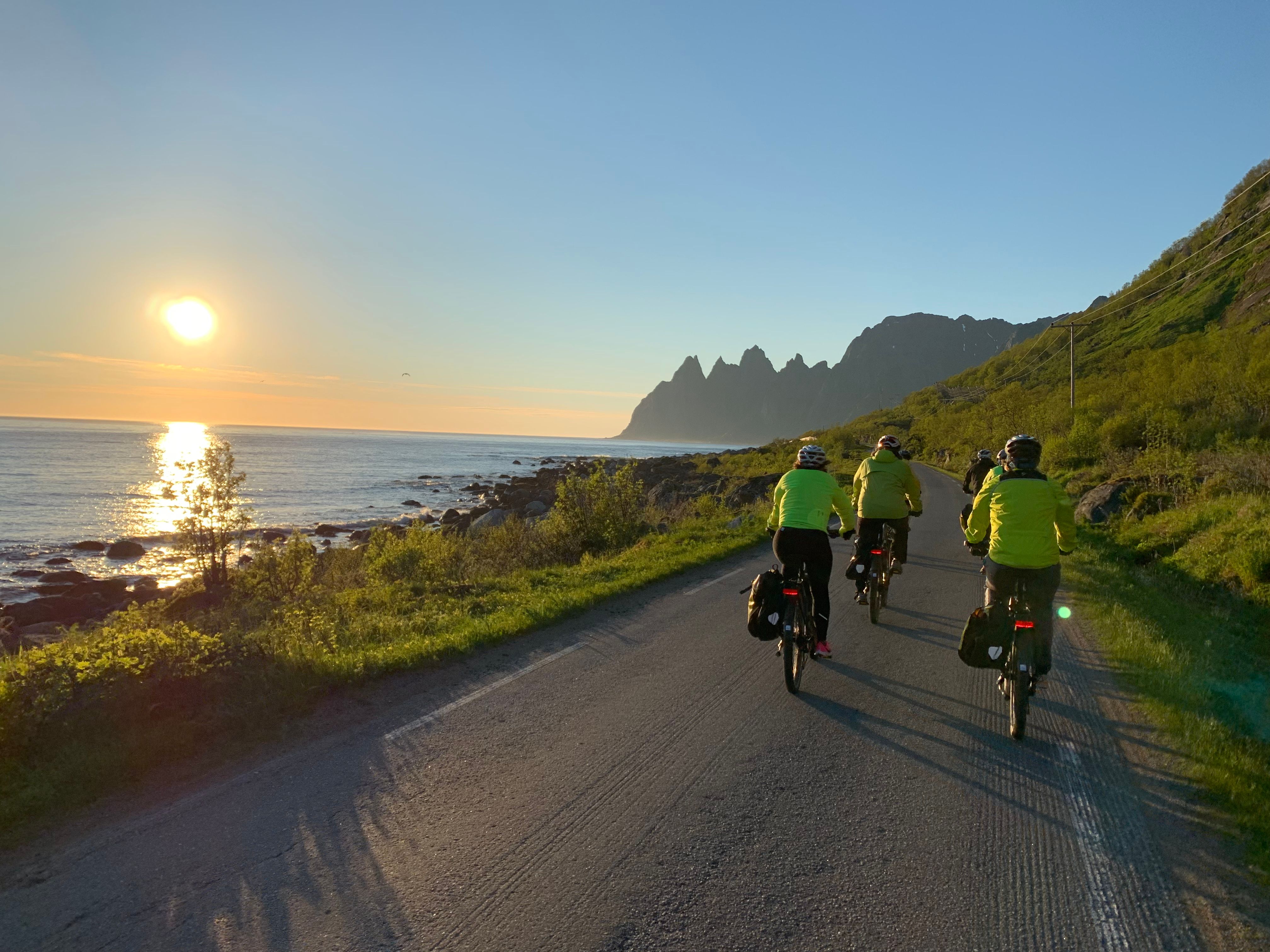 People cycling under the midnight sun in Senja