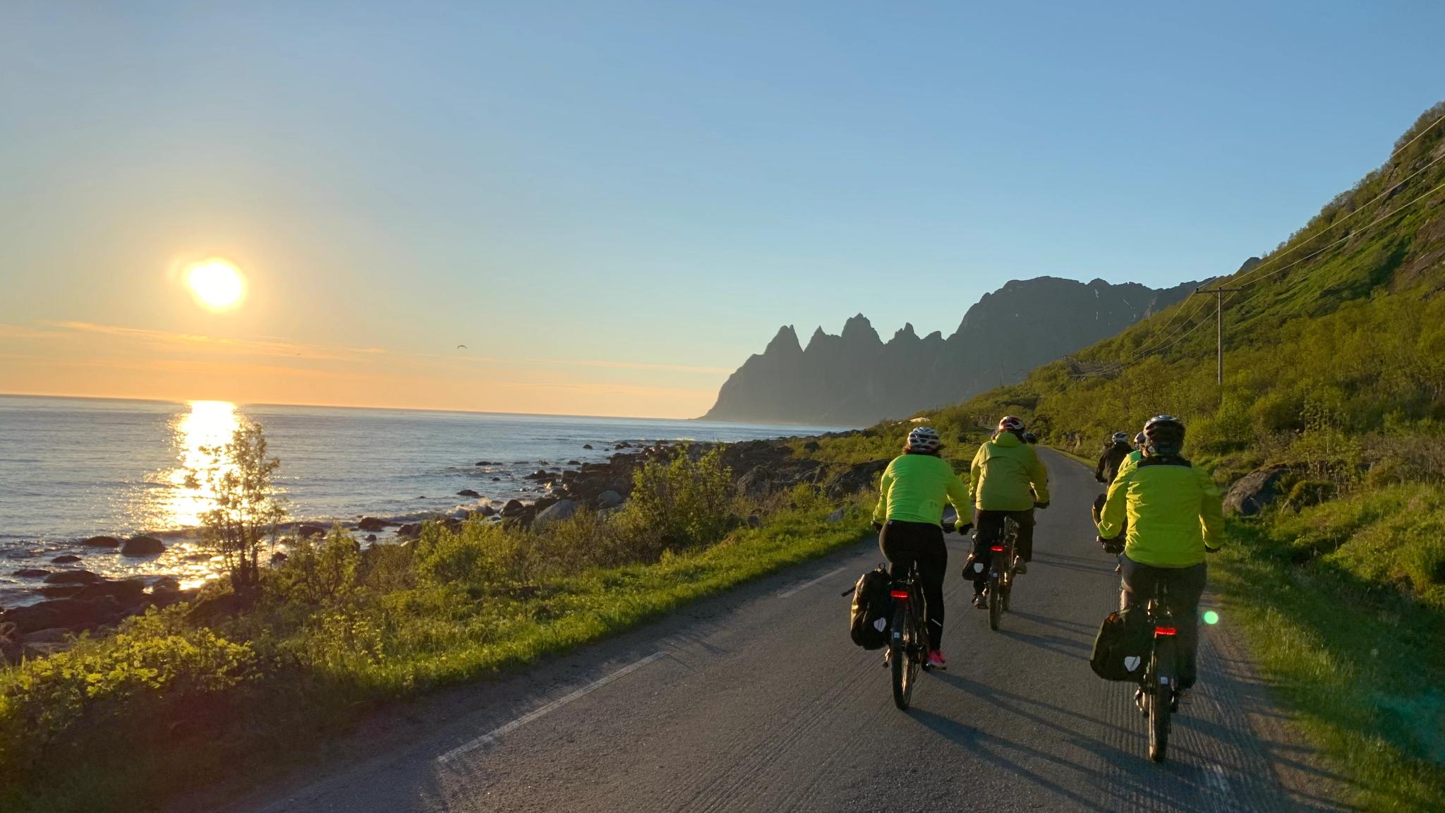 People cycling under the midnight sun in Senja