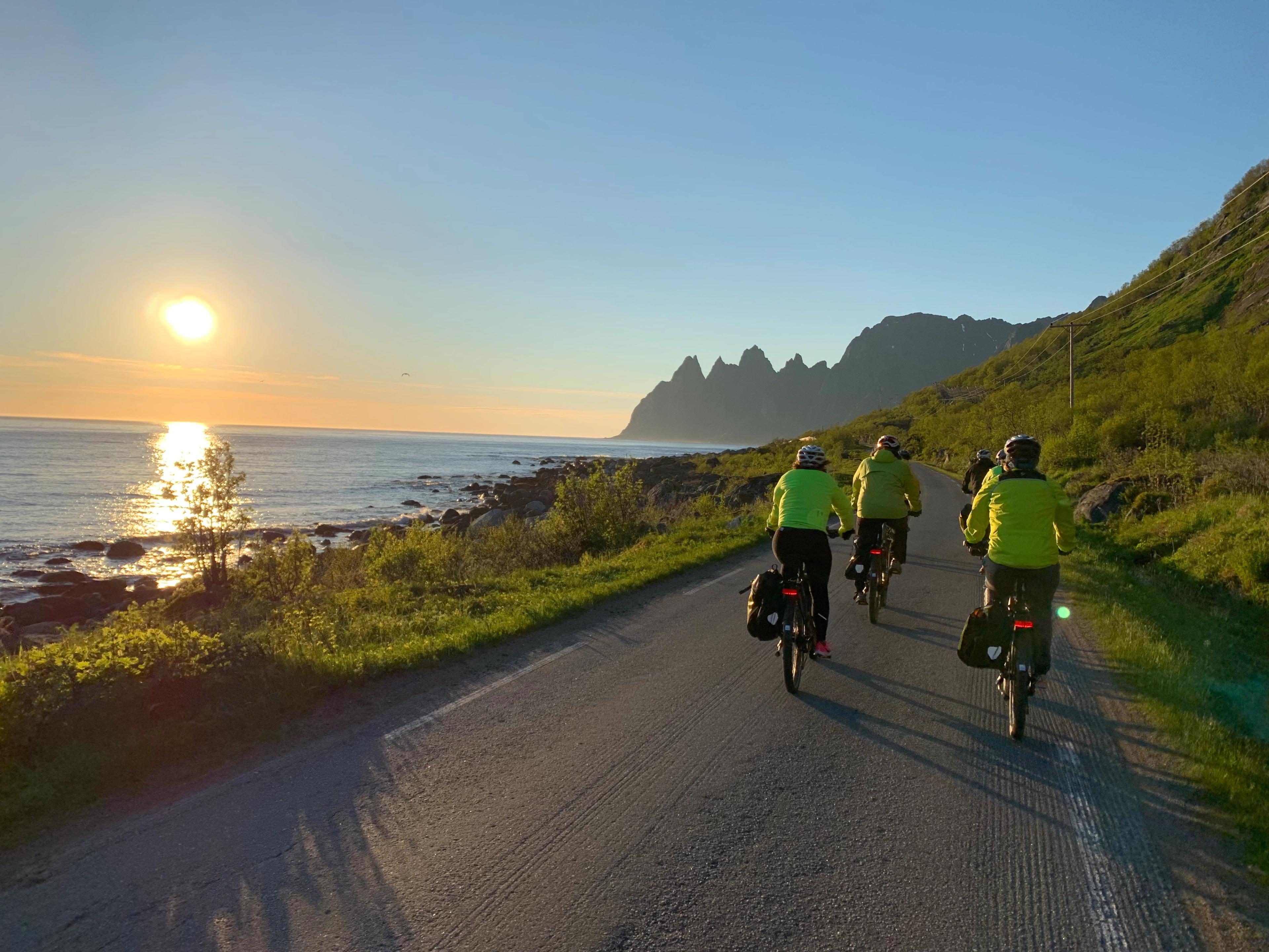 People cycling under the midnight sun in Senja