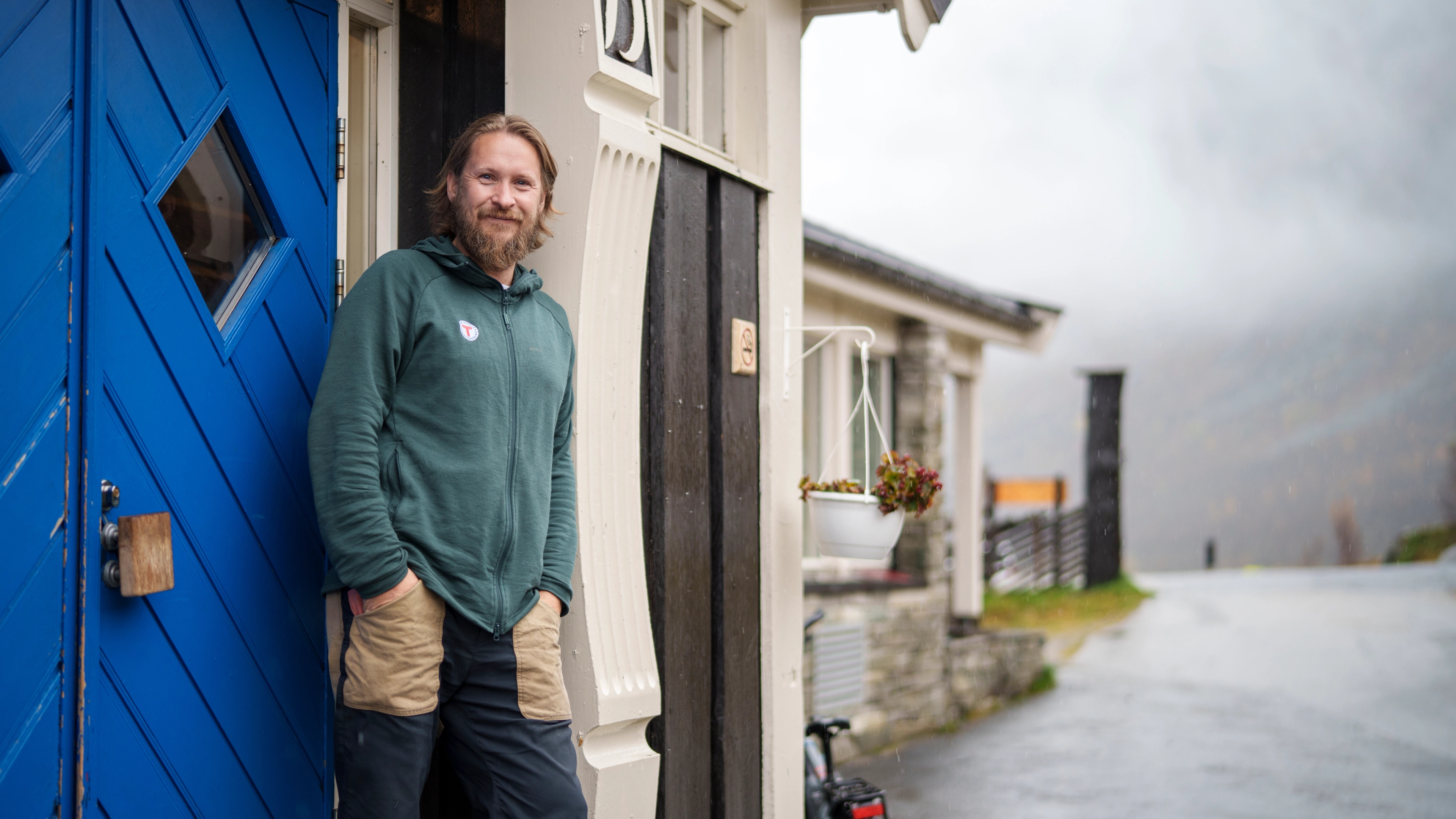 A man outside a mountain lodge