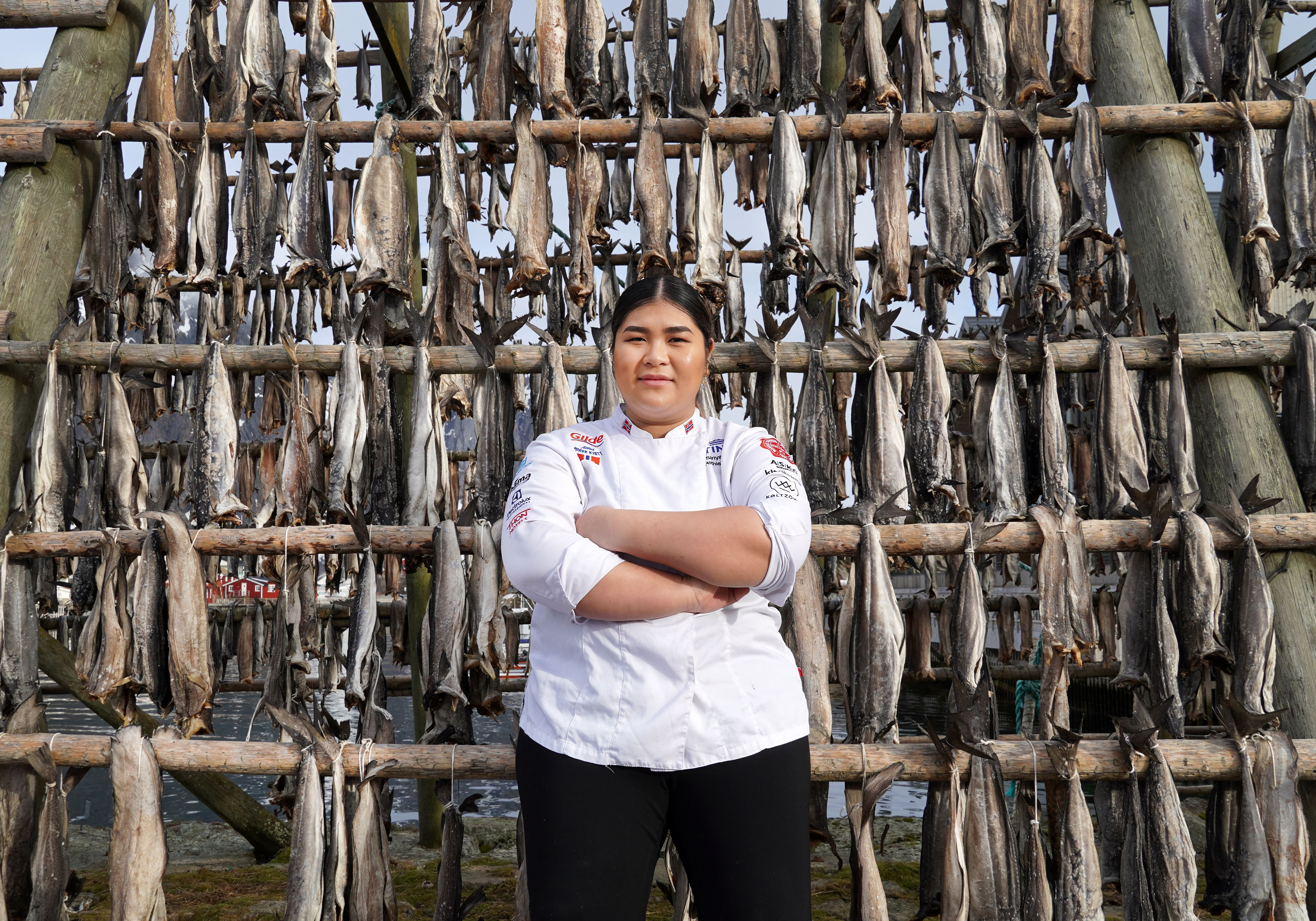 A young chef in front of stockfish racks
