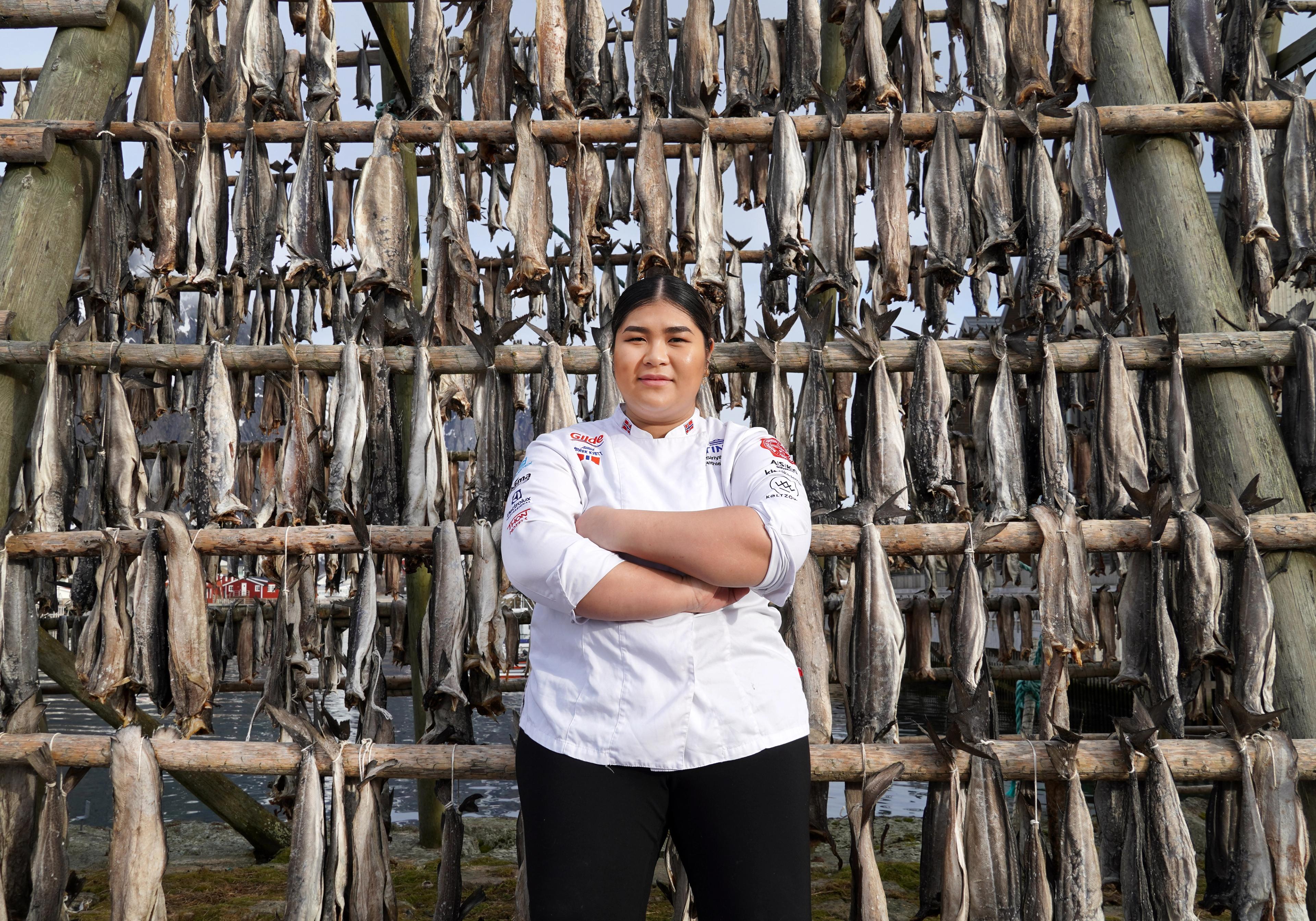 A young chef in front of stockfish racks