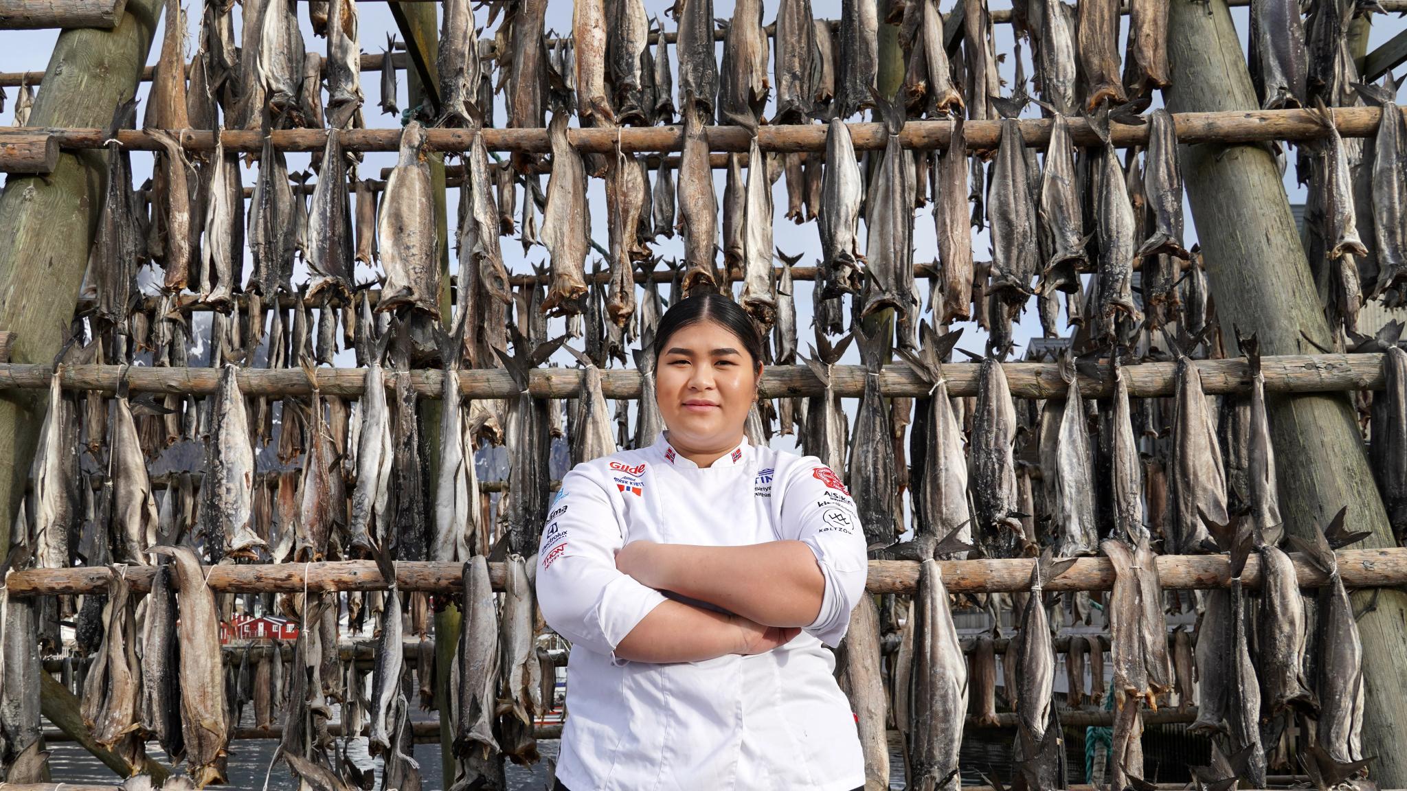 A young chef in front of stockfish racks