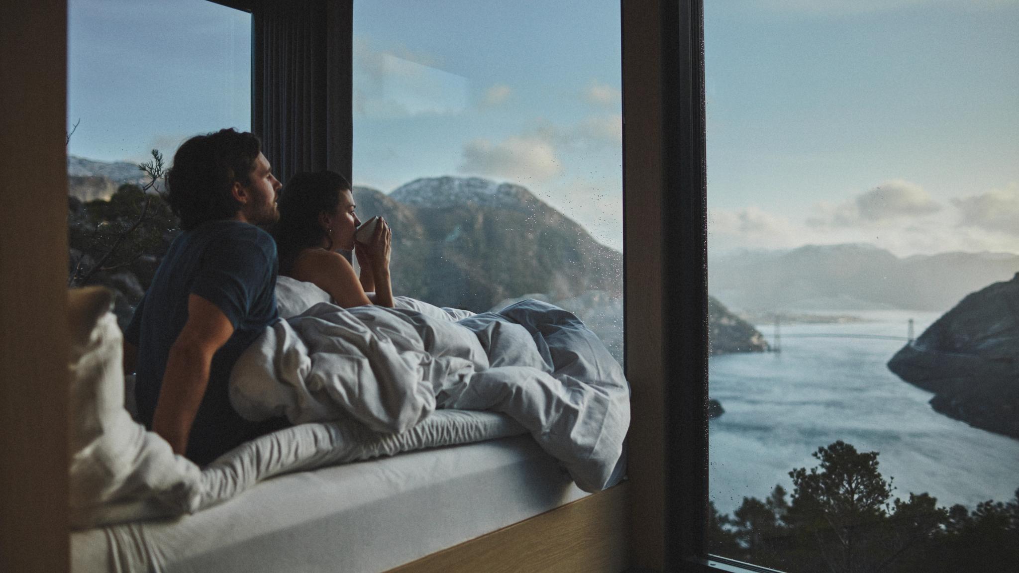 Couple in bed looking at the view over Lysefjorden in Rogaland, Fjord norway