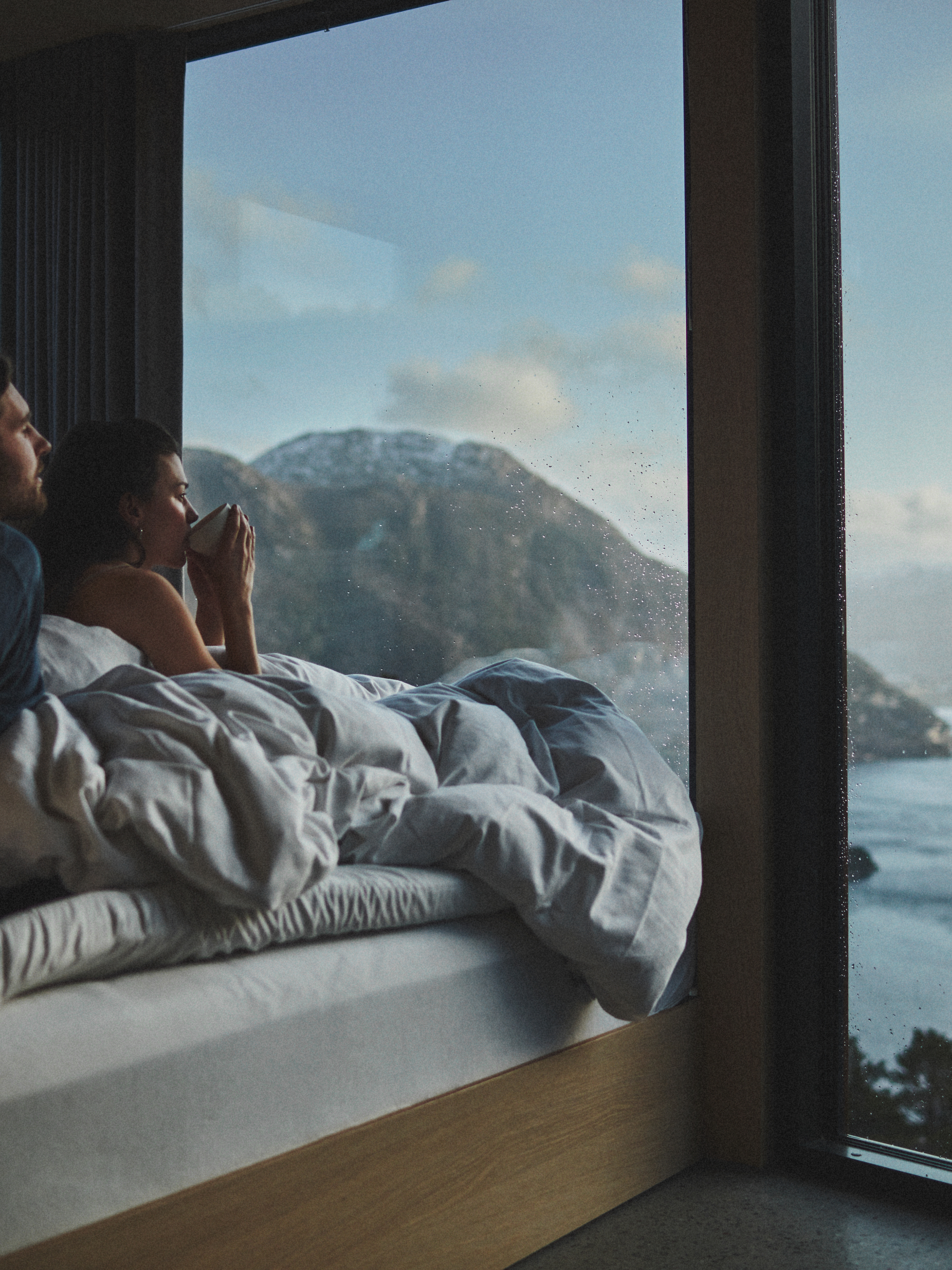 Couple in bed looking at the view over Lysefjorden in Rogaland, Fjord norway