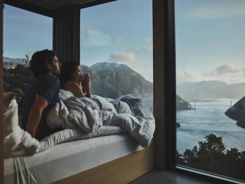 Couple in bed looking at the view over Lysefjorden in Rogaland, Fjord norway