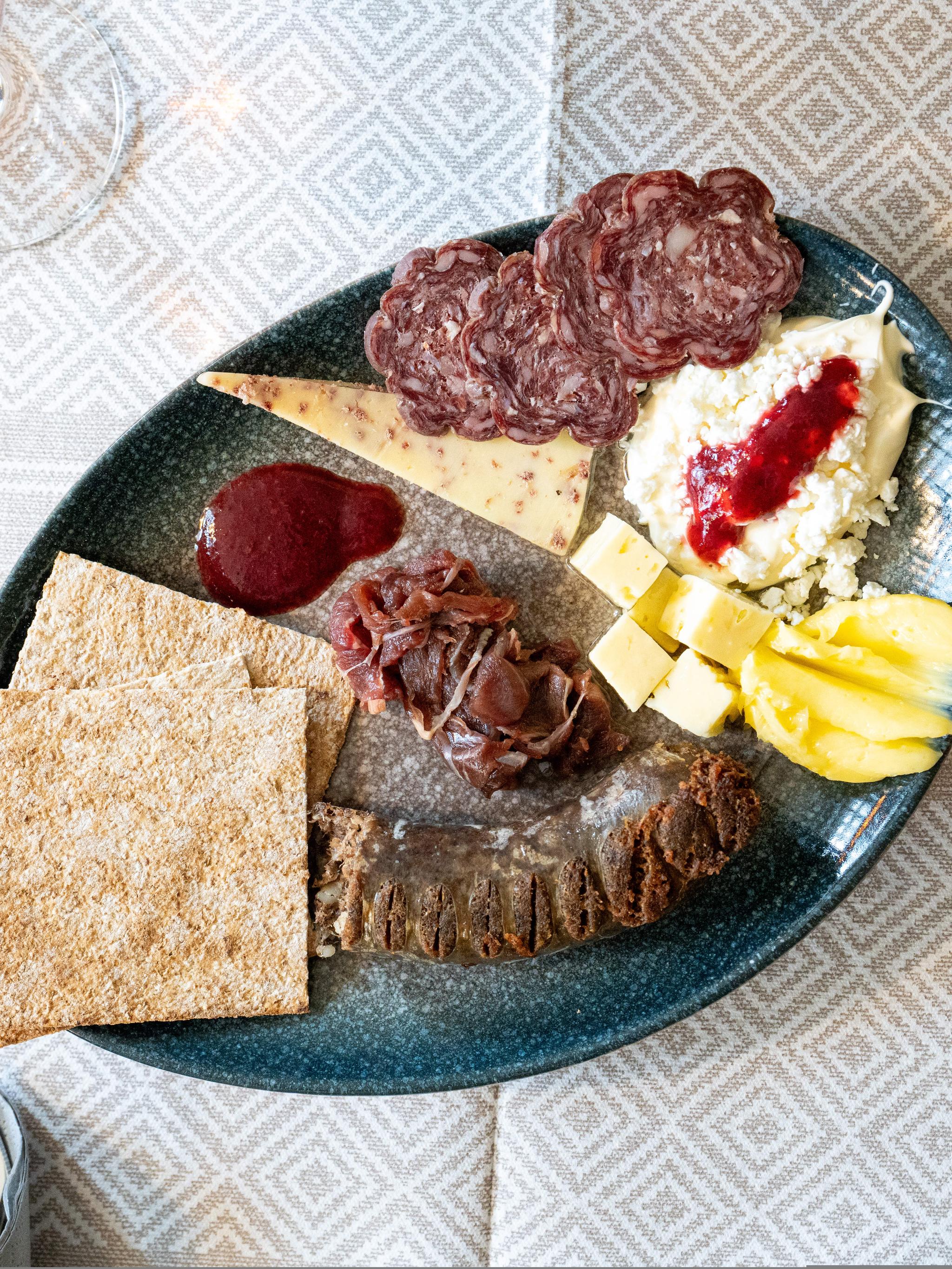 A plate full of dried meats and cheeses