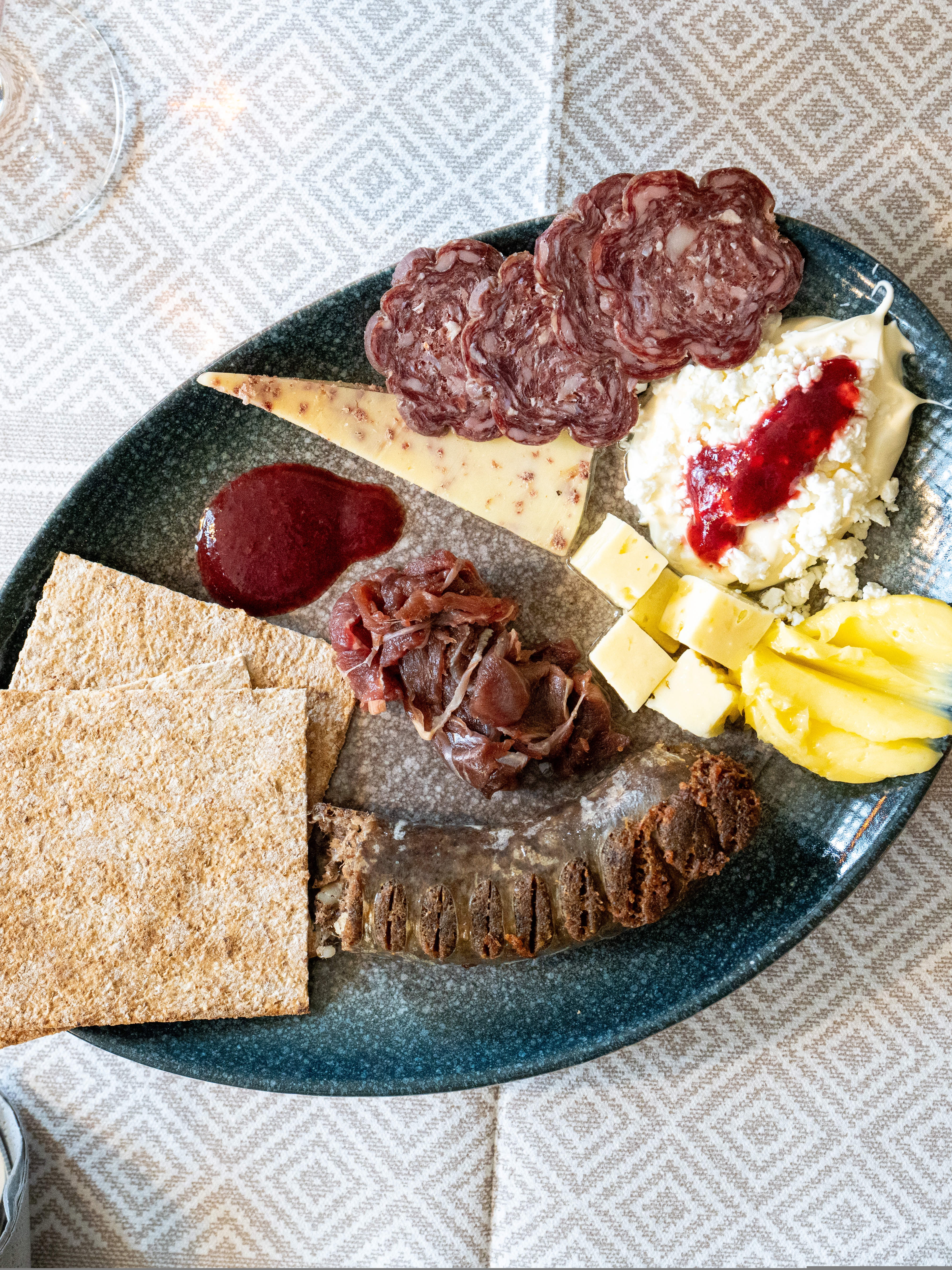 A plate full of dried meats and cheeses
