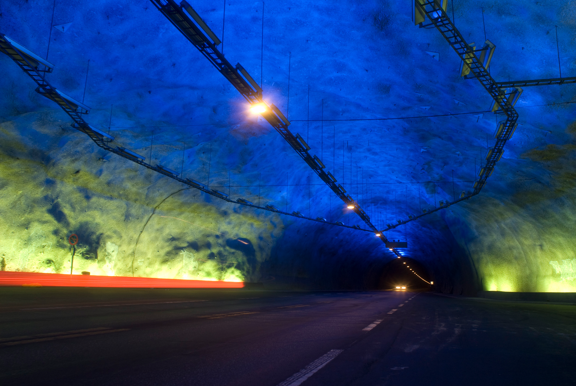 Inside of a tunnel lit up by blue and yellow lights