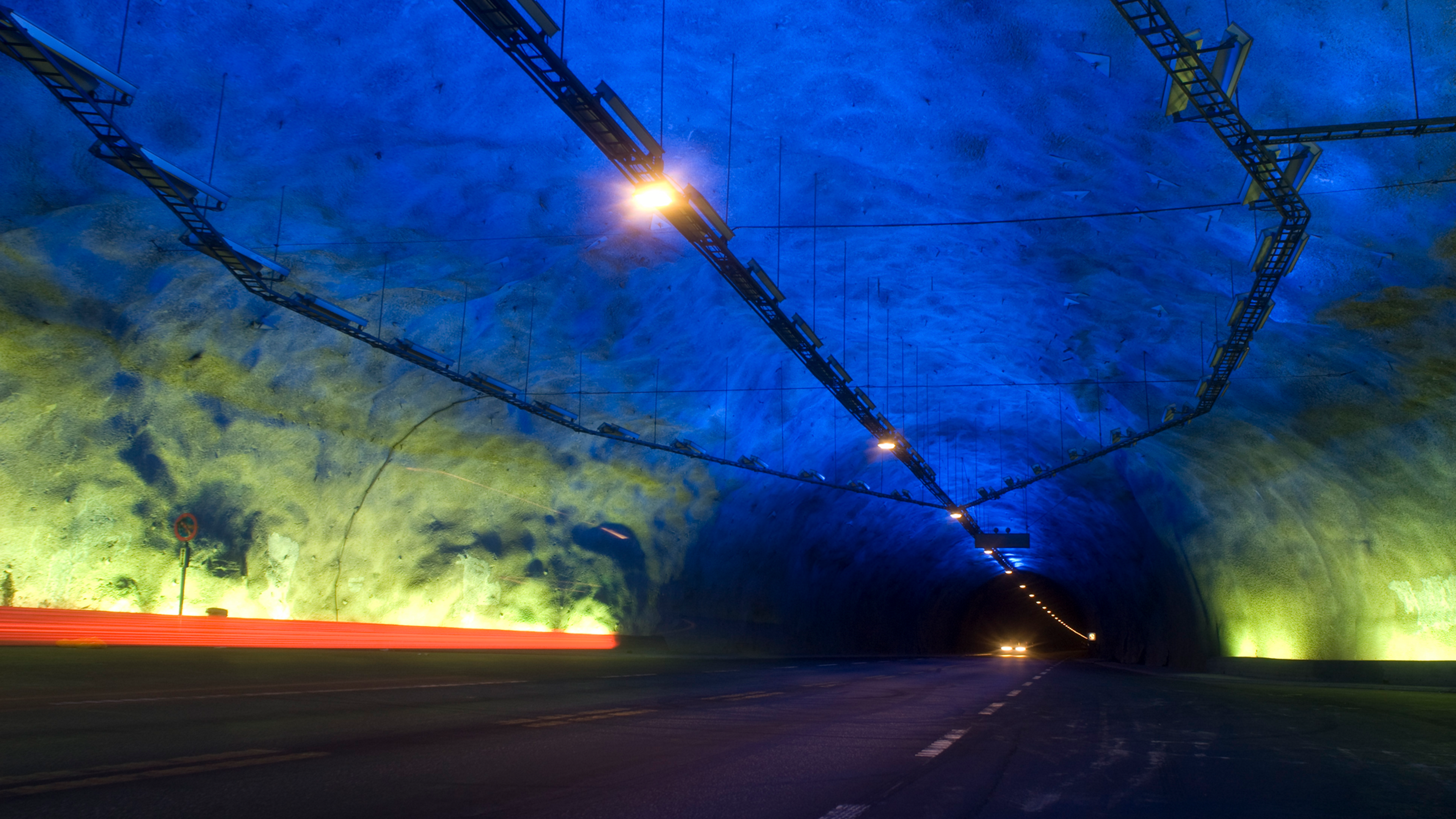Inside of a tunnel lit up by blue and yellow lights