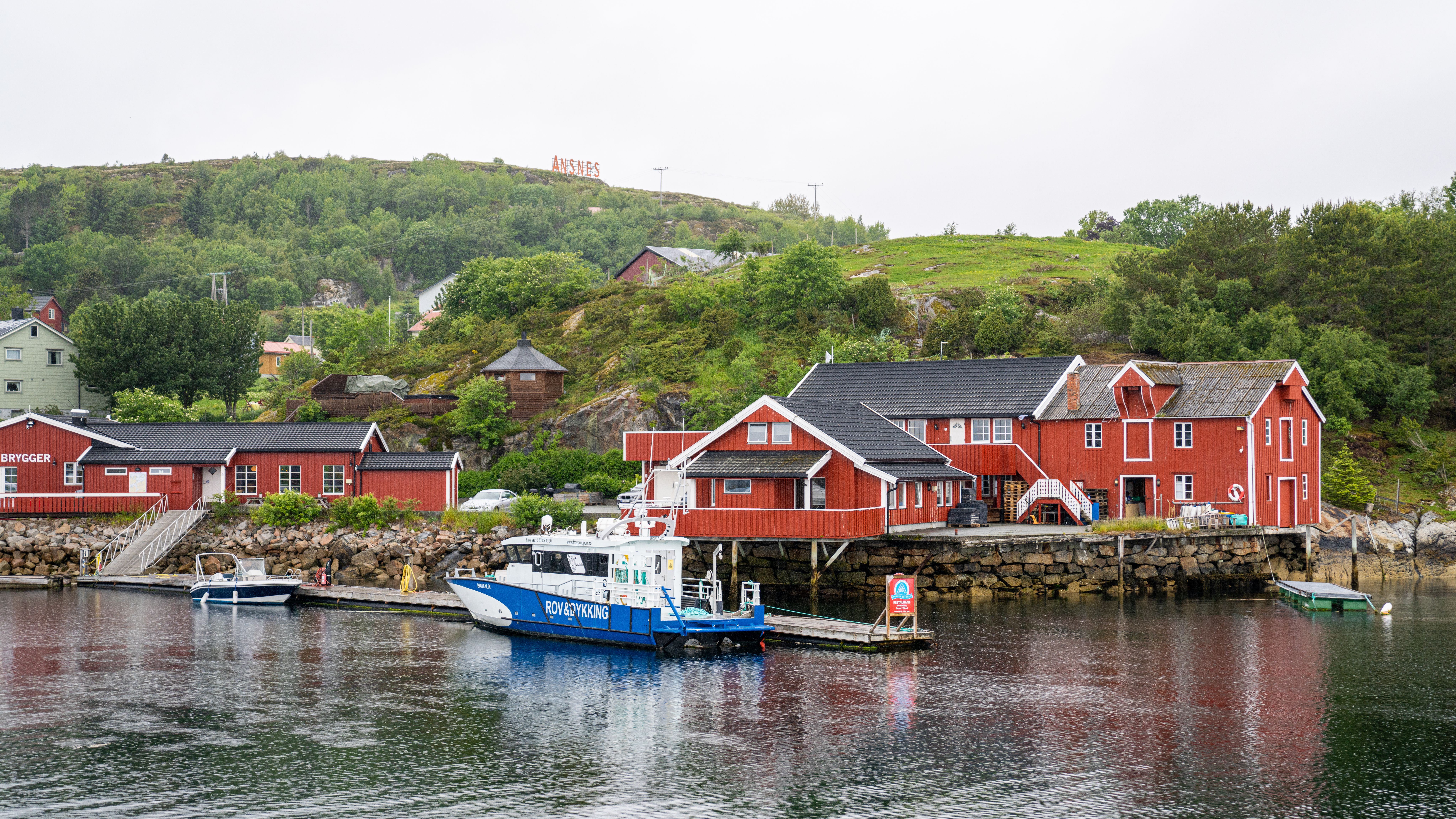 A fishing boat in front of a harbour at Hitra.