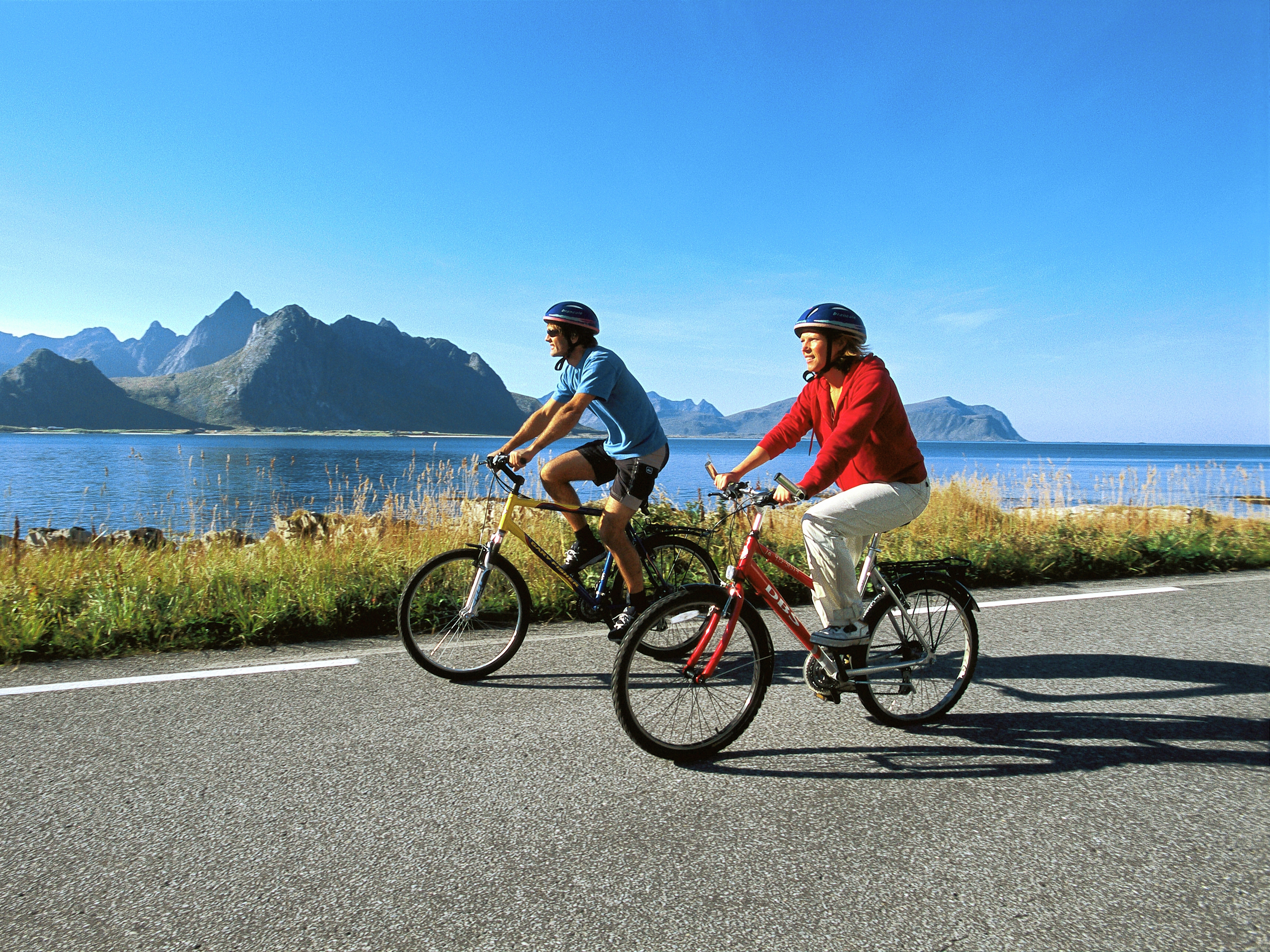 Two people cycling along the coast of Lofoten in Northern Norway