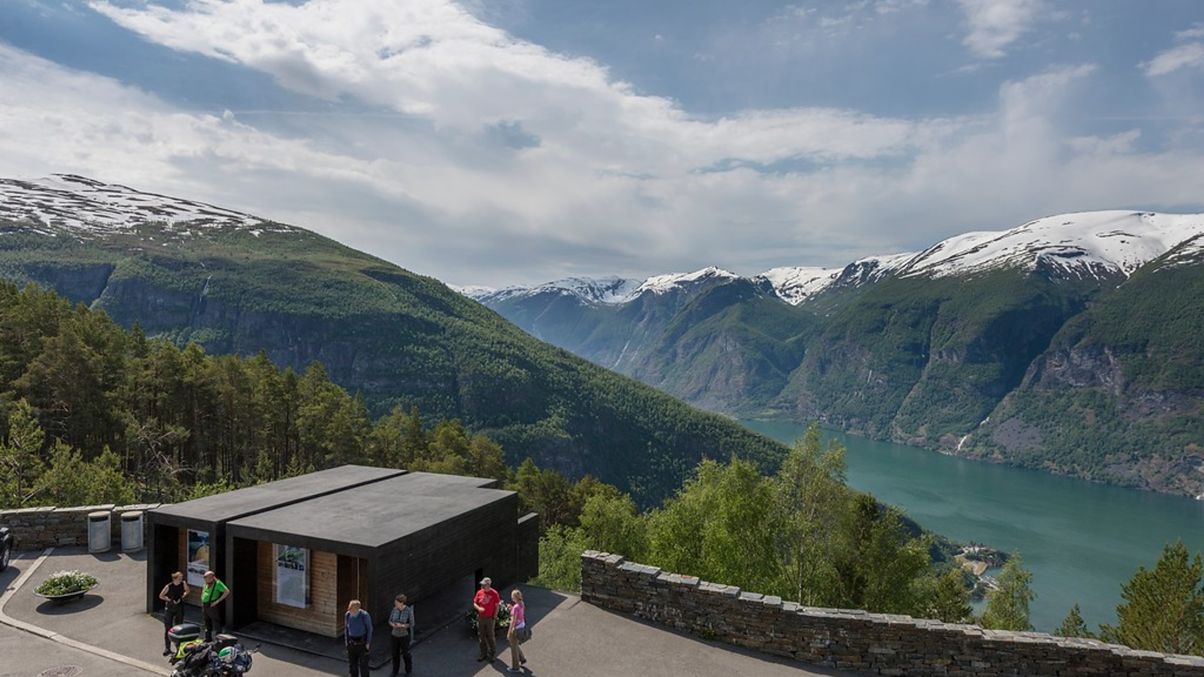 Motorcyclists resting by restrooms overlooking the fjord