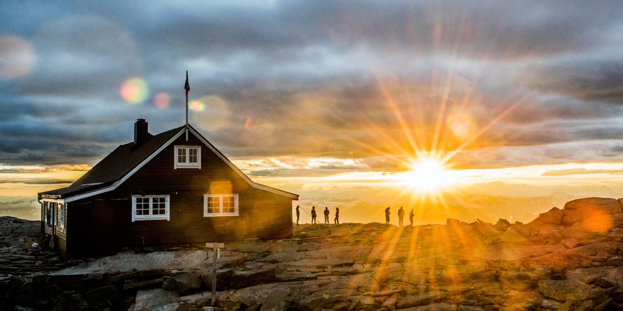 People watching the sunset at the Fannaråken cabin in Jotunheimen, Norway