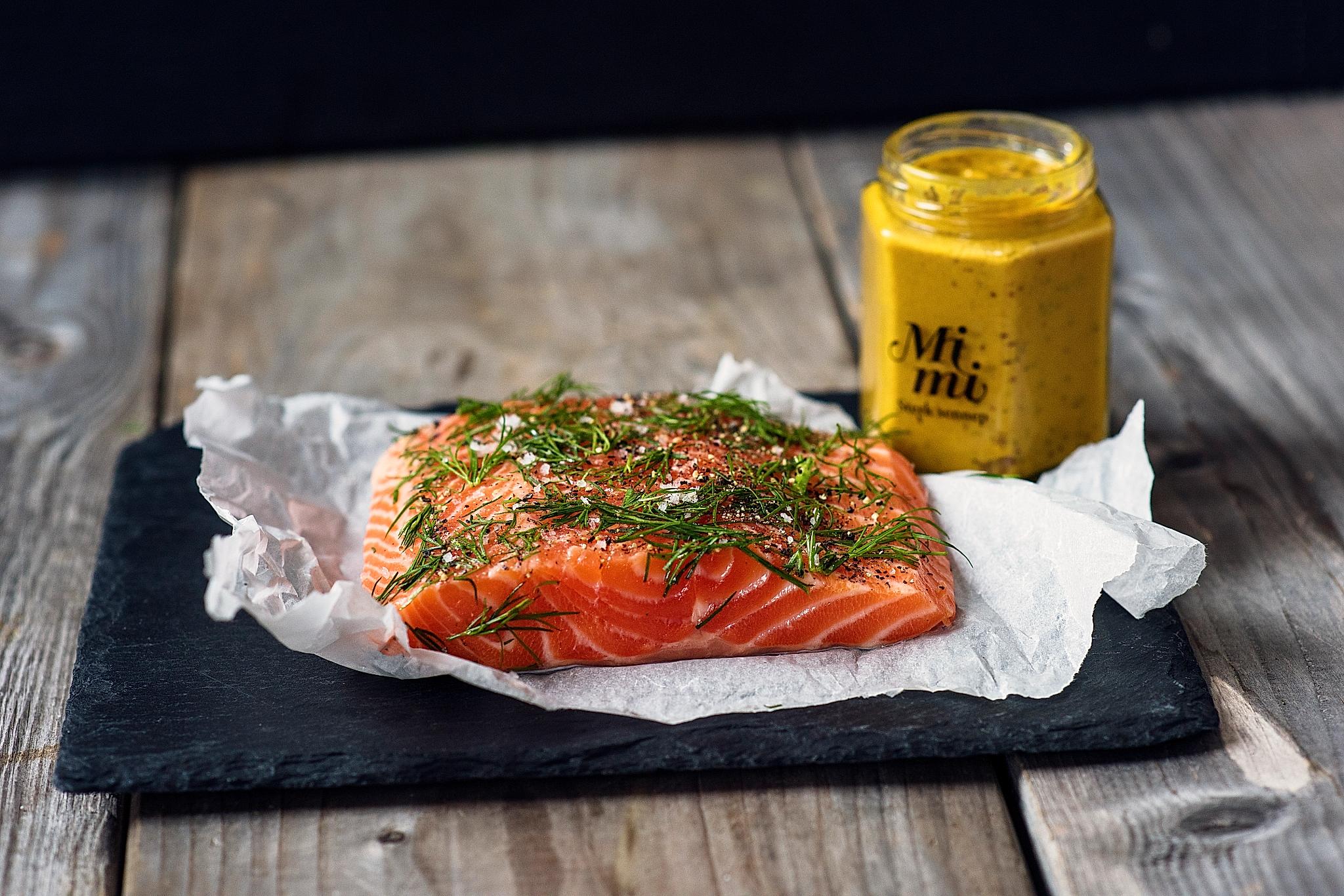 A fresh piece of raw salmon topped with various herbs