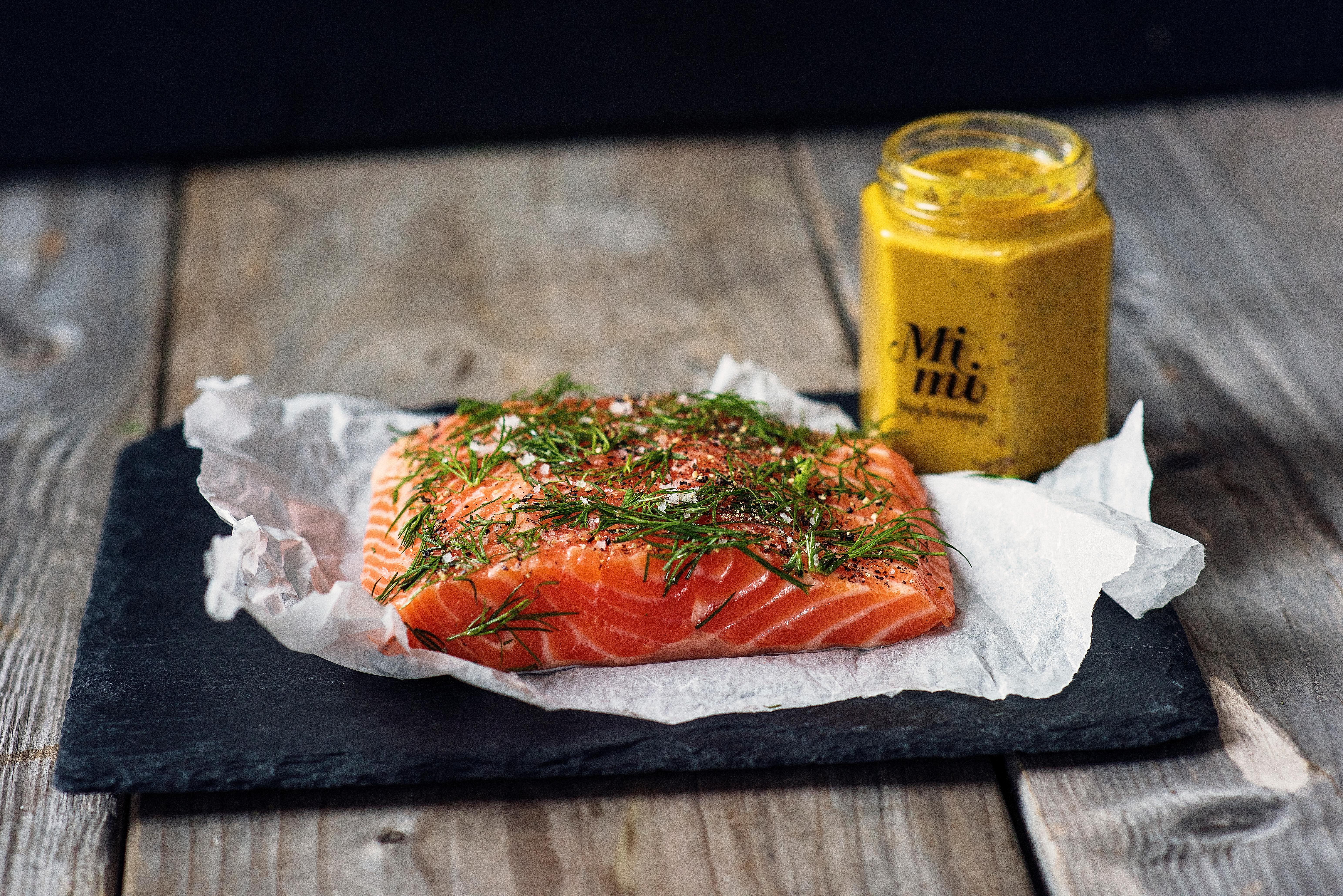 A fresh piece of raw salmon topped with various herbs