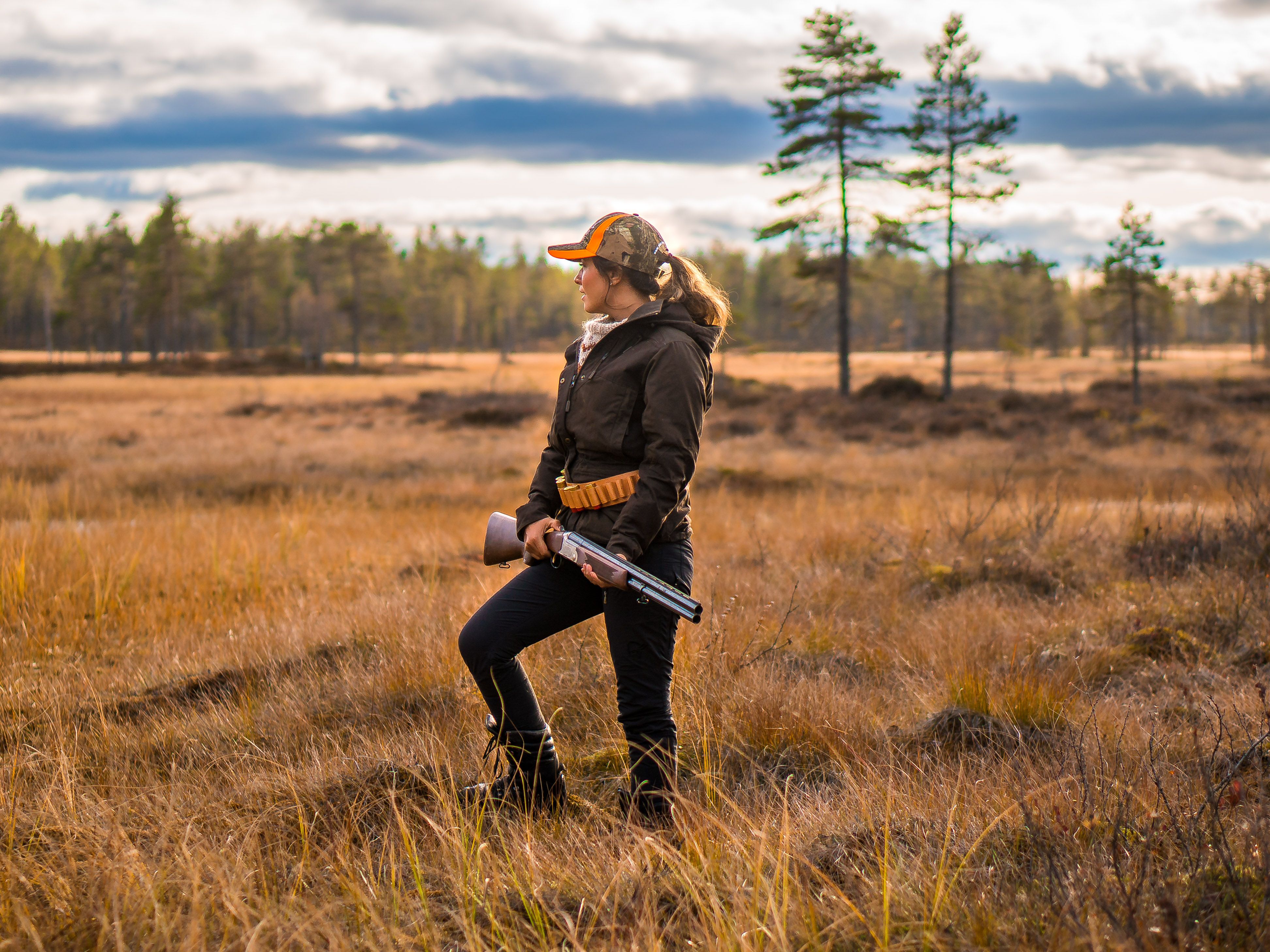 En kvinne jakter i skogen om høsten