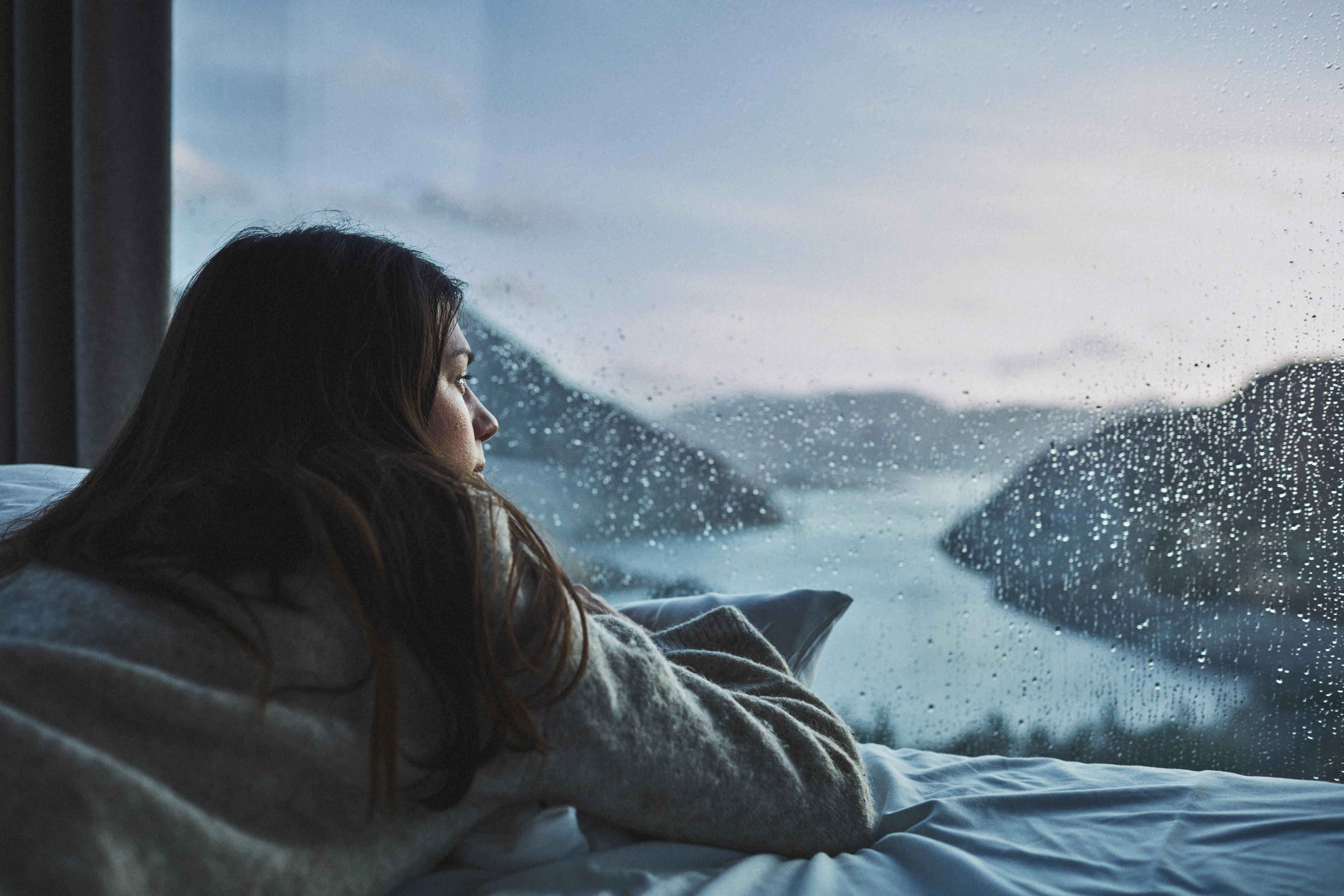 Woman in bed looking at the view over Lysefjorden from the Bolder in Rogaland, Fjord Norway