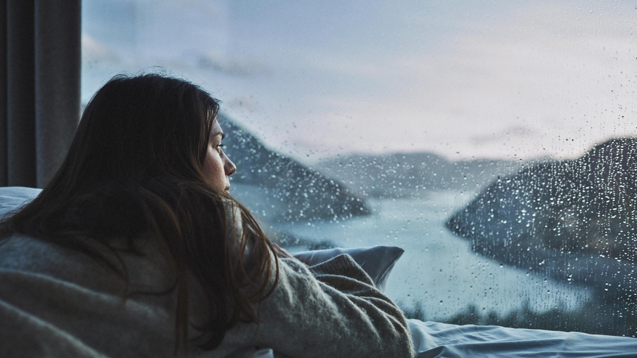 Woman in bed looking at the view over Lysefjorden from the Bolder in Rogaland, Fjord Norway