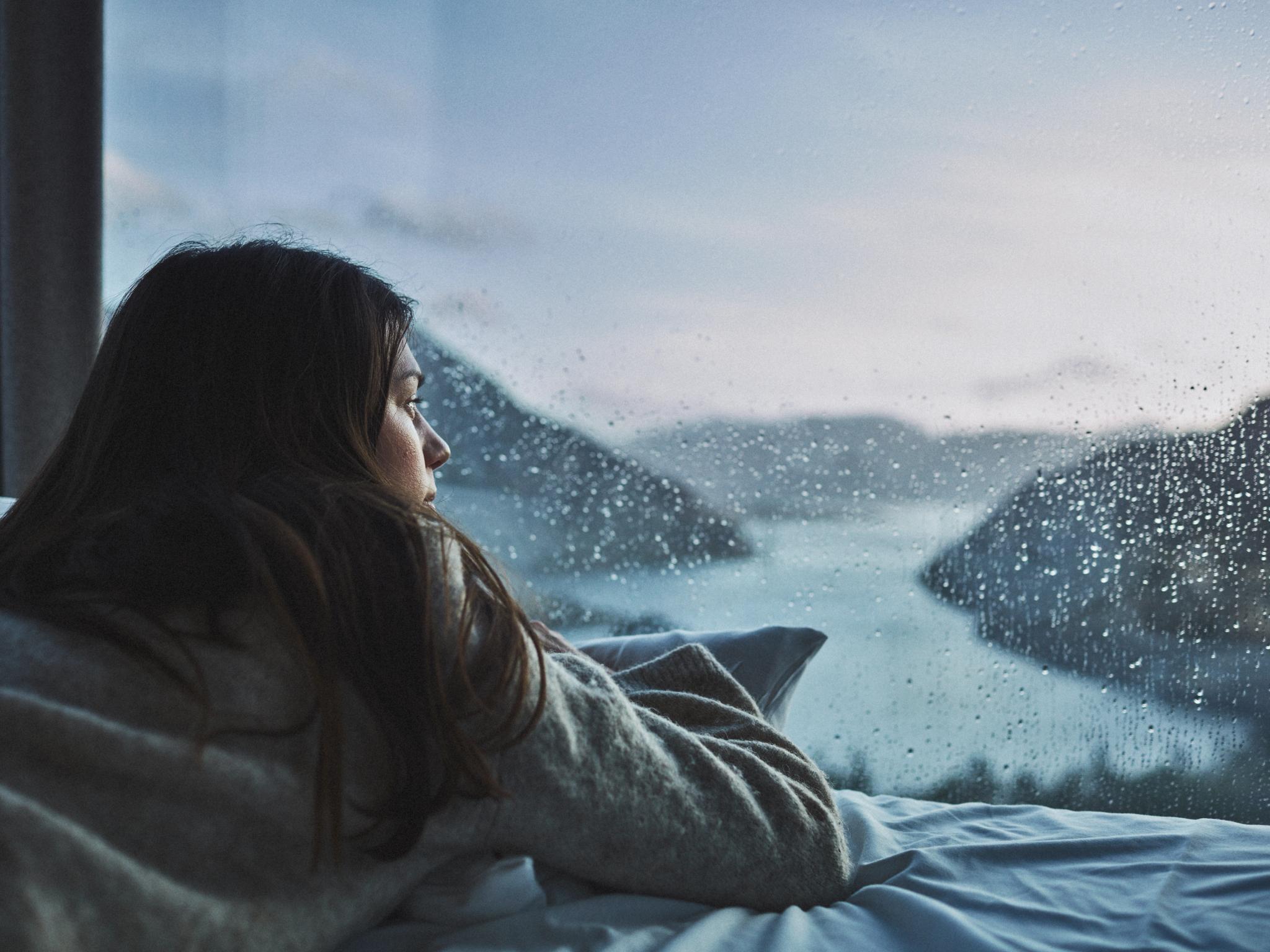 Woman in bed looking at the view over Lysefjorden from the Bolder in Rogaland, Fjord Norway