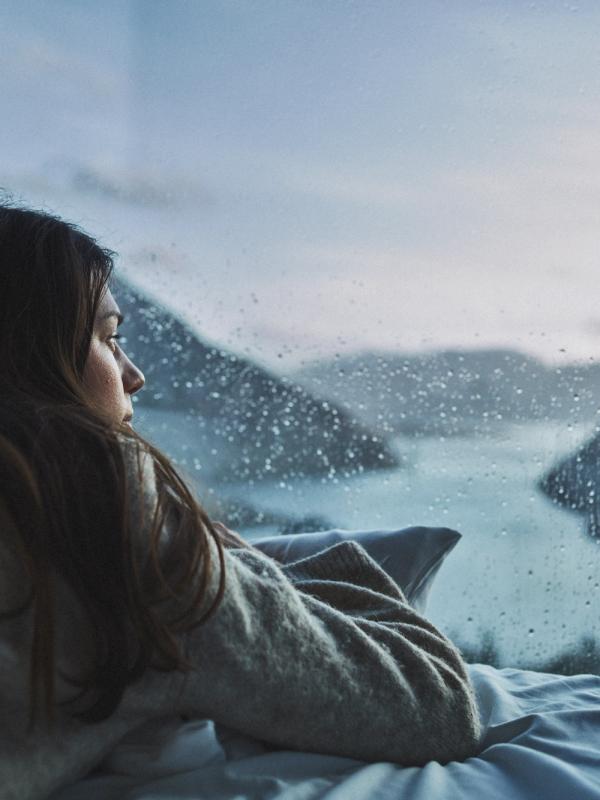 Woman in bed looking at the view over Lysefjorden from the Bolder in Rogaland, Fjord Norway
