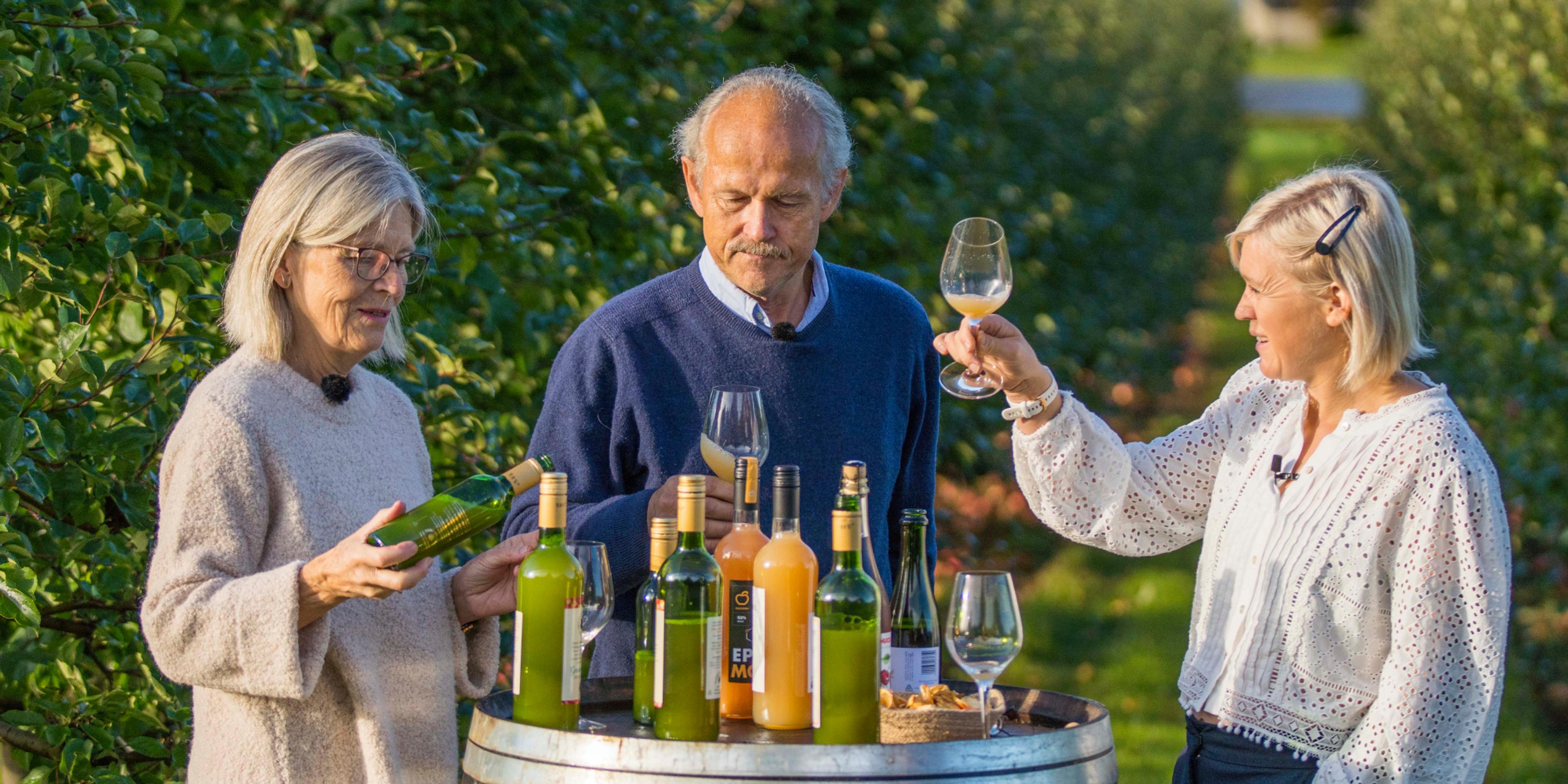 Three people tasting apple juice made of Aroma apples in the Fruit Village